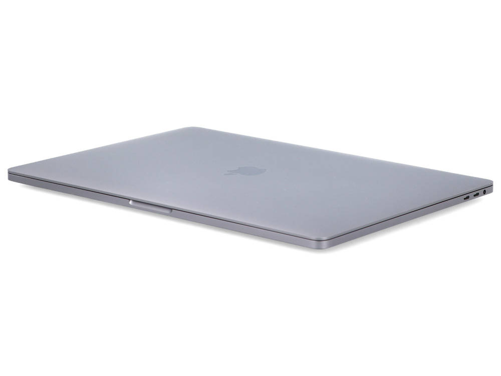 Zamknięty szary laptop na białej powierzchni.