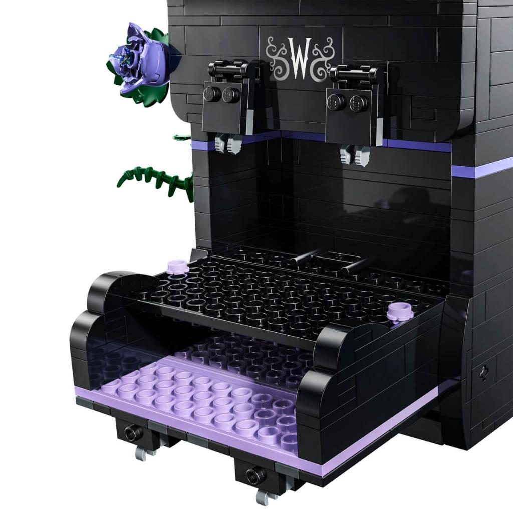 Mor detaylara ve açık bir çekmeceye sahip siyah bir Lego kahve makinesi modeli.