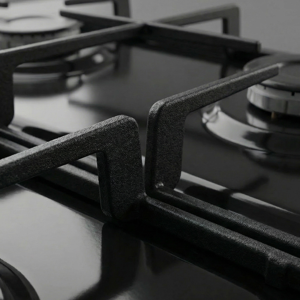 Close-up of a modern black gas stove with cast iron grates and burners.