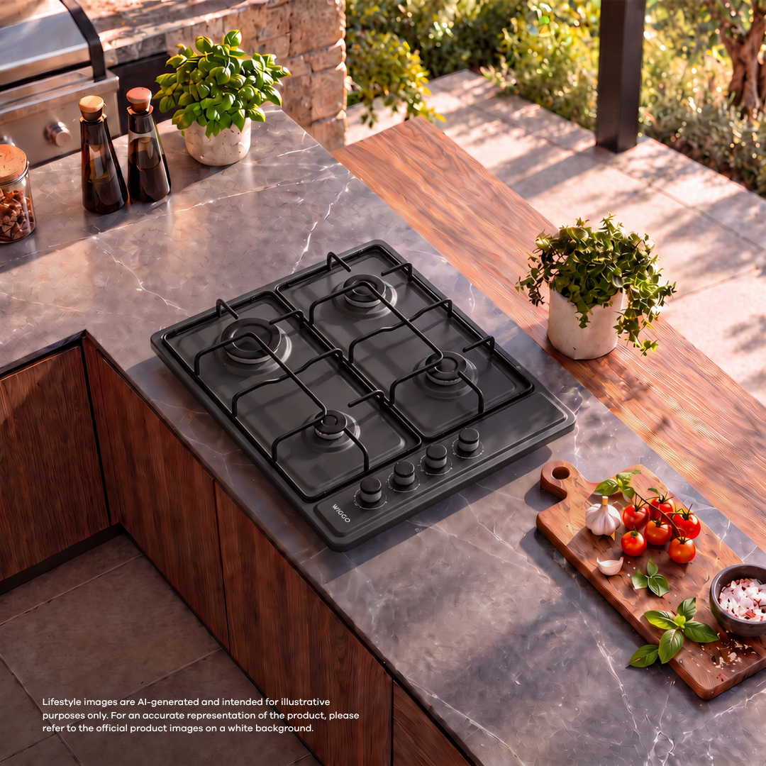 A black gas cooktop on an outdoor marble countertop with herbs and tomatoes nearby.