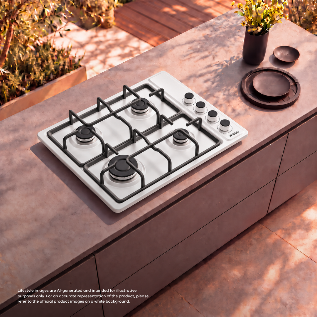 A white gas cooktop on an outdoor counter with four burners, control knobs, and a flower vase nearby.