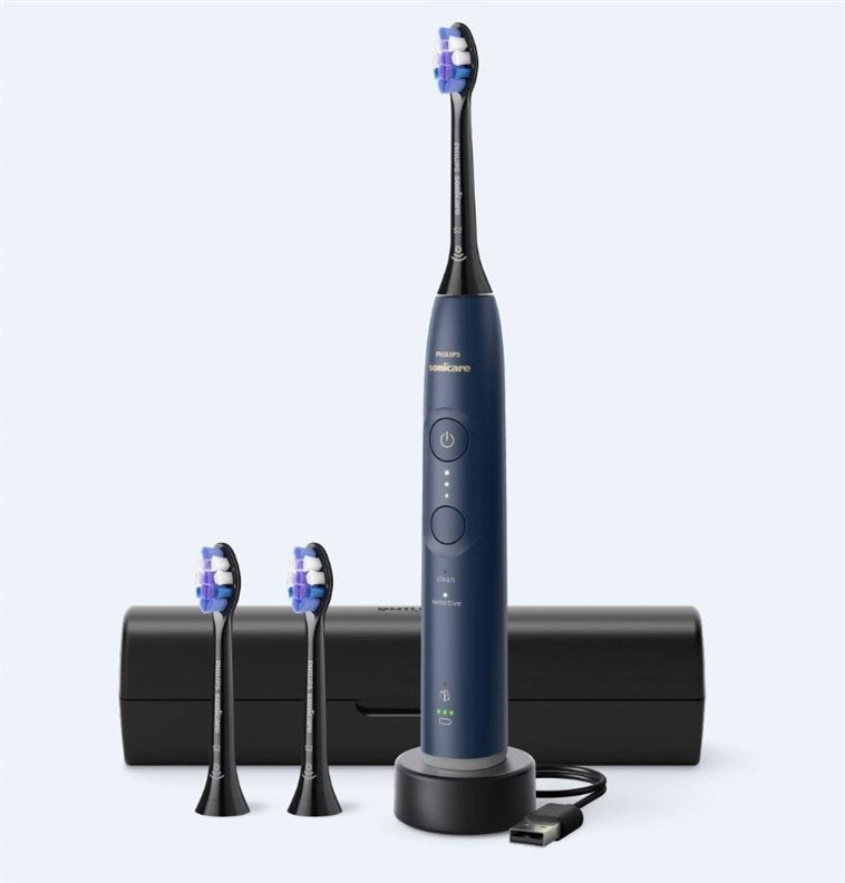Uno spazzolino elettrico Philips Sonicare blu scuro su base di ricarica, con due testine di ricambio e una custodia.