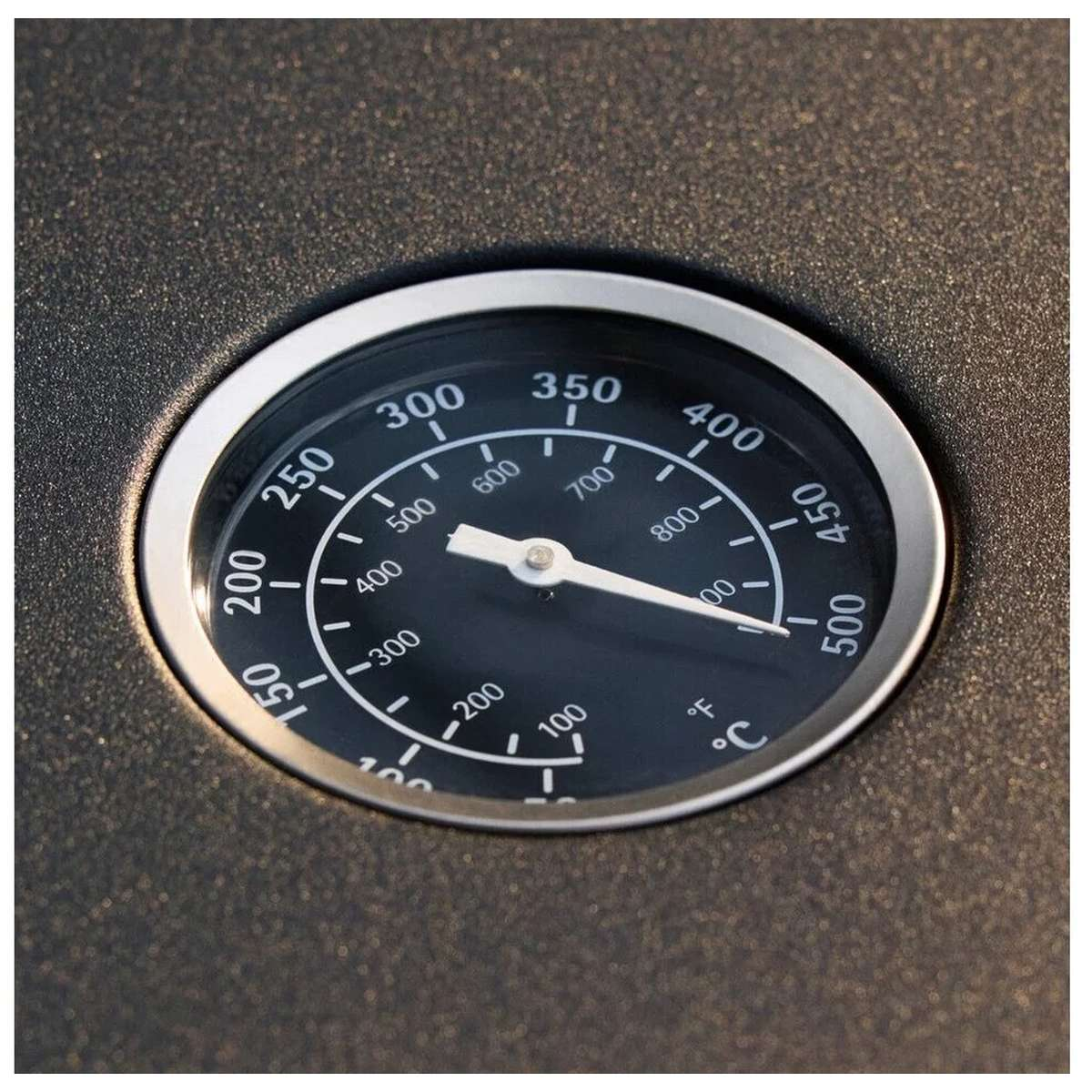 Un termometro rotondo su una superficie scura mostra Fahrenheit e Celsius.