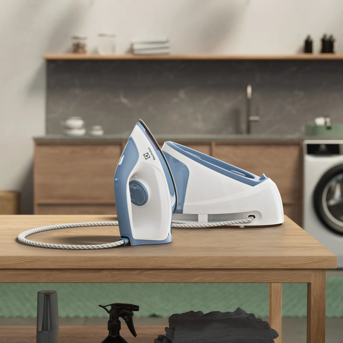 Un ferro da stiro a vapore bianco e blu con base poggiato su un tavolo di legno in cucina.