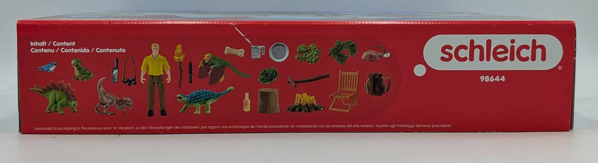 Eine rote Schleich-Spielzeugverpackung zeigt eine Übersicht der enthaltenen Dinosaurier-Figuren und Zubehörteile.