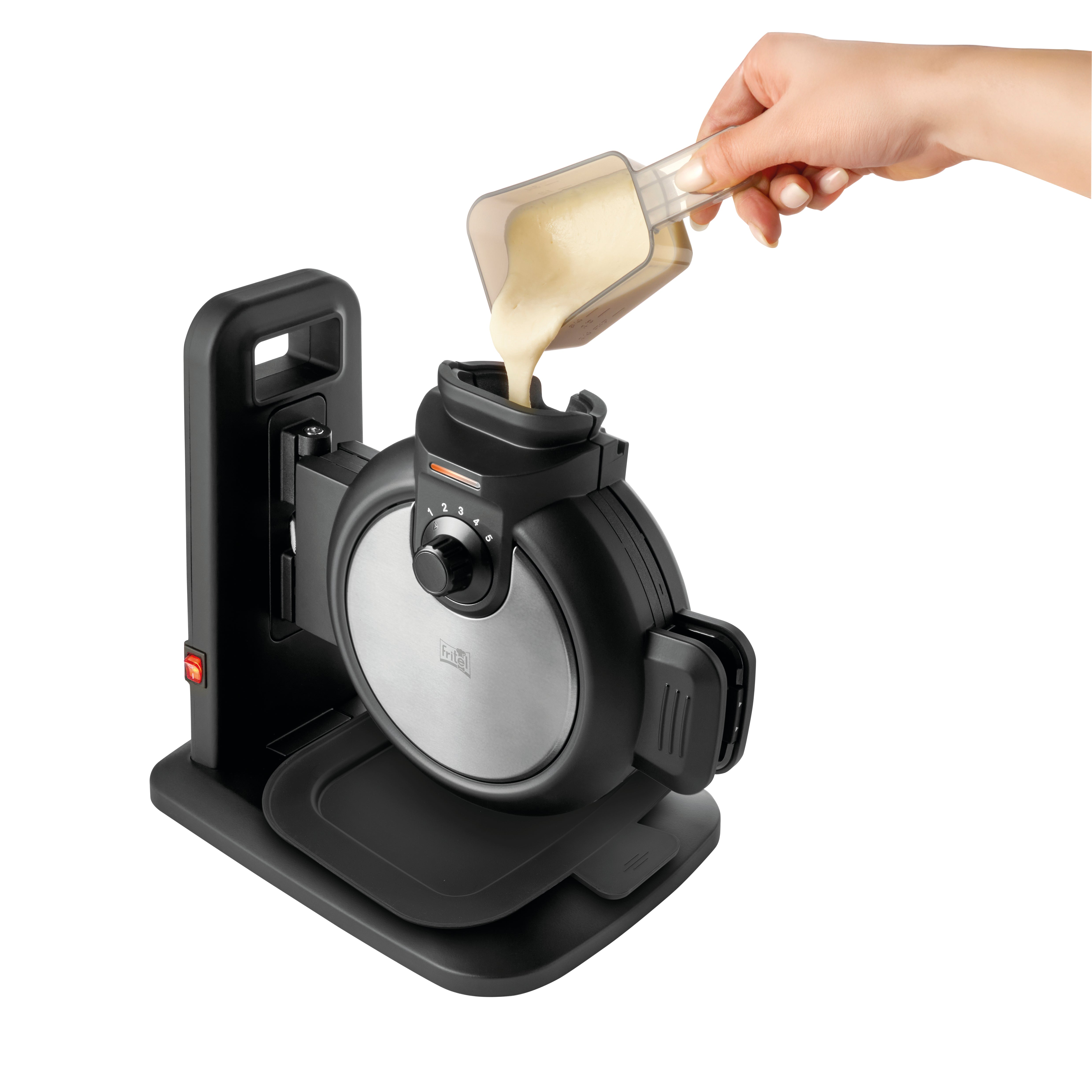 A hand pours batter from a measuring cup into a black waffle maker.