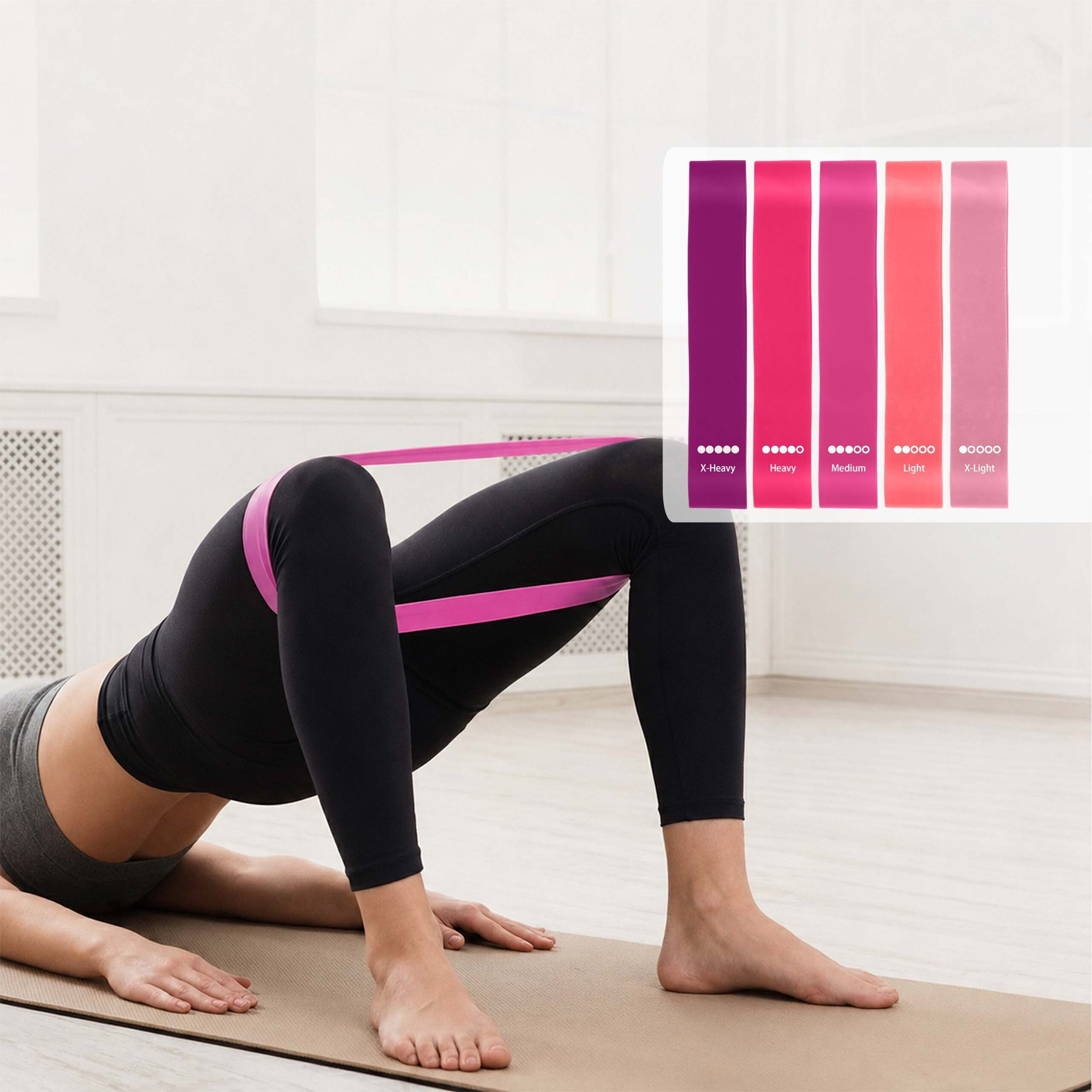 Eine Frau in Leggings macht eine Beckenbrücke auf einer Matte mit einem pinken Widerstandsband um ihre Beine.
