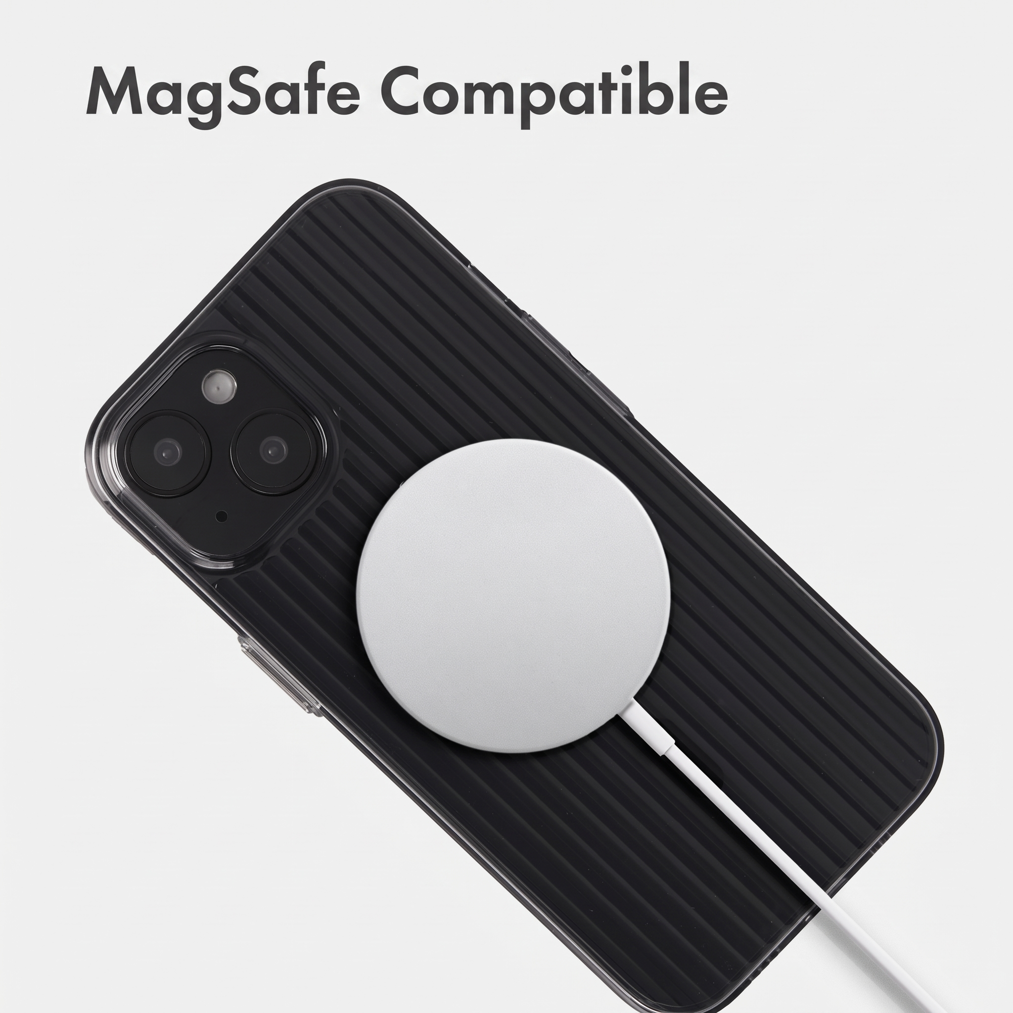A white MagSafe charger attached to the back of a black iPhone inside a ribbed protective case.