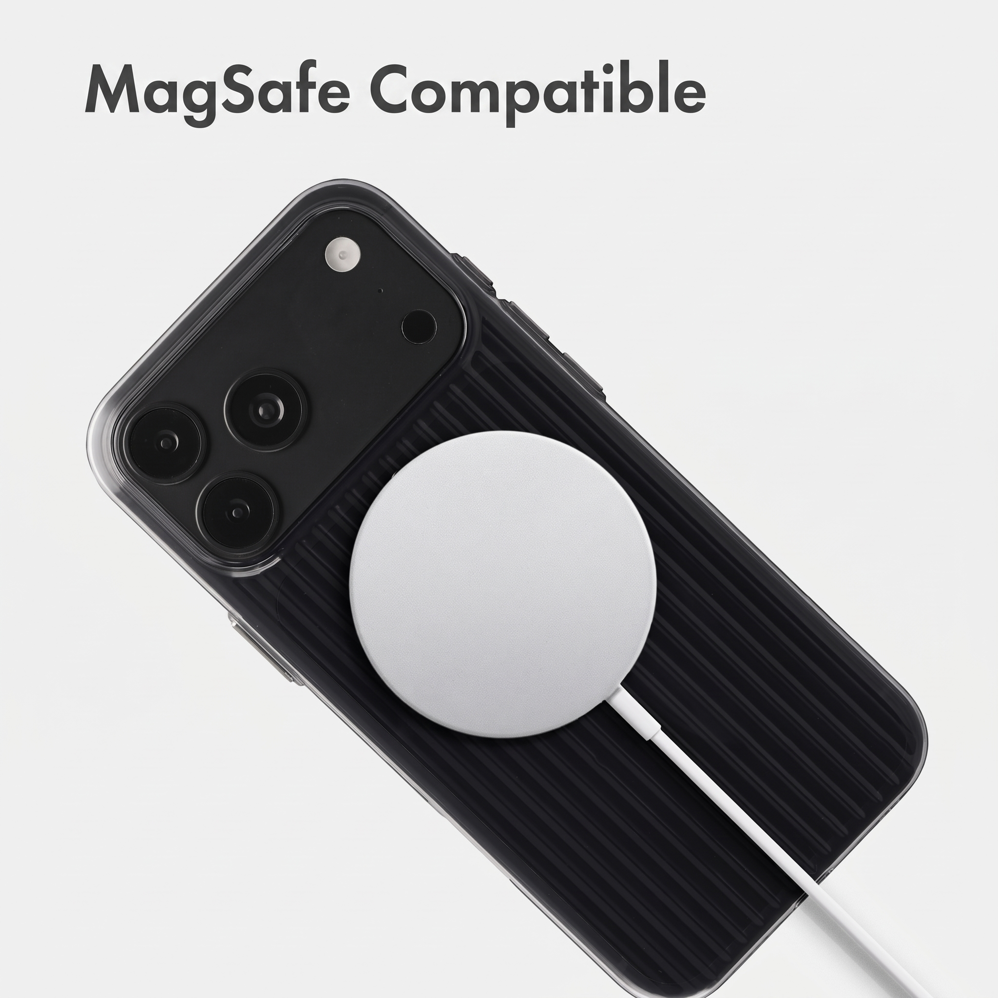 Ein Smartphone in schwarzer Schutzhülle mit MagSafe-Ladegerät auf weißem Grund.