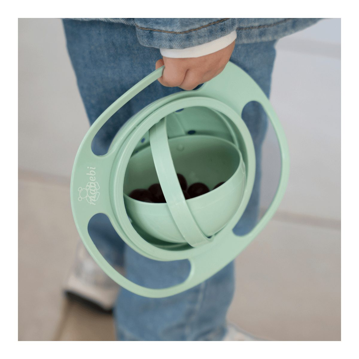 Person in Jeans hält eine grüne Gyro-Schüssel mit Beeren.