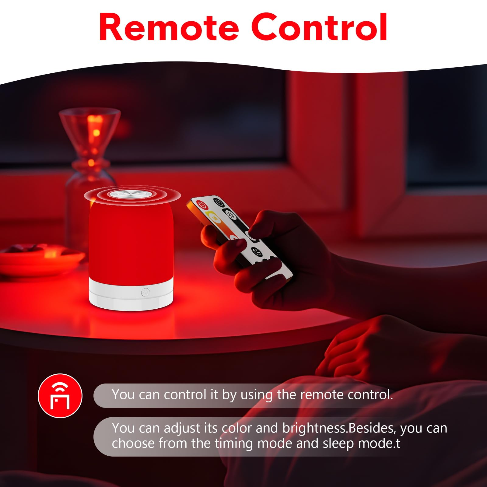 Hand hält eine Fernbedienung für eine rote Lampe auf dem Tisch.