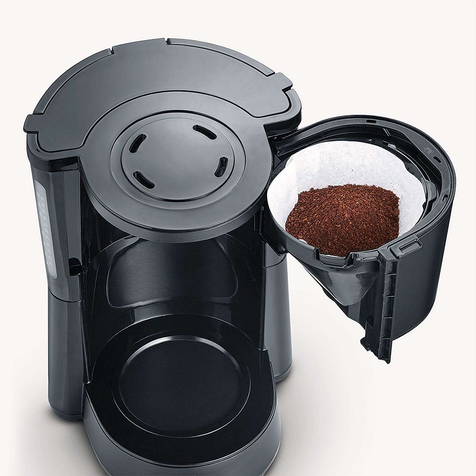 Eine schwarze Kaffeemaschine mit geöffnetem Filterhalter und Kaffeemehl.