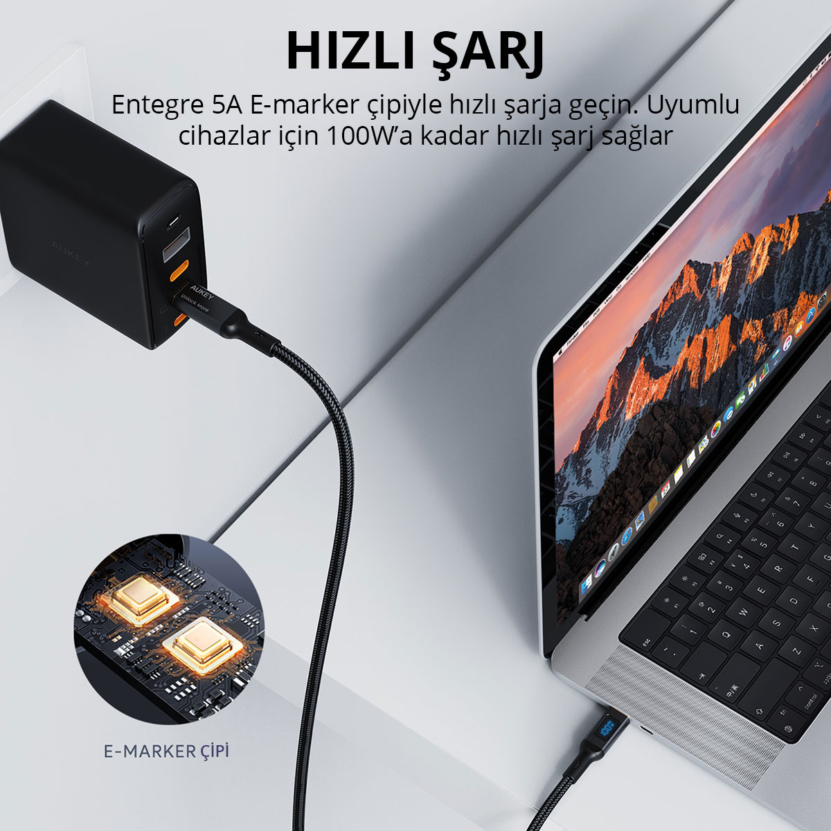 Siyah bir şarj cihazı, E-marker çipli kablo aracılığıyla dizüstü bilgisayarı şarj ediyor.