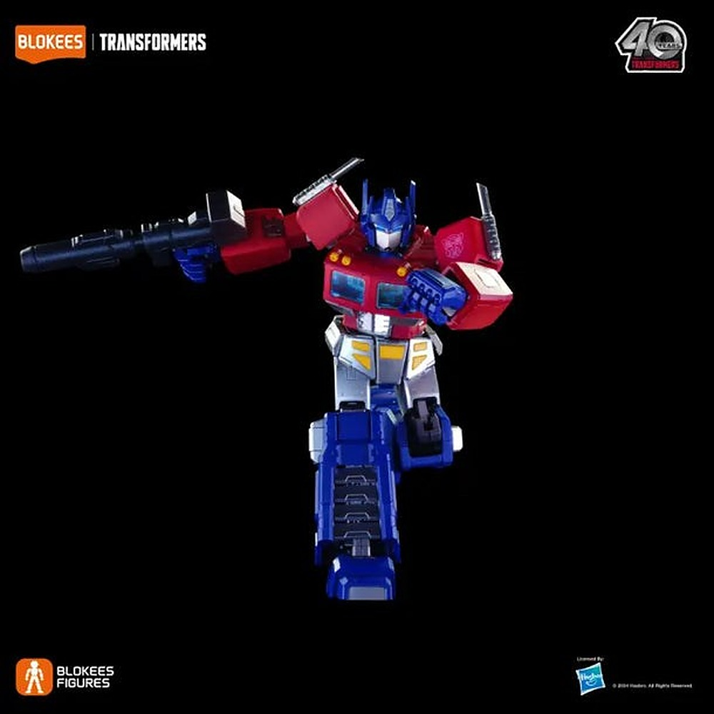 Czerwono-niebieska figurka akcji Optimus Prime z Transformers w dynamicznej pozie z bronią na czarnym tle.