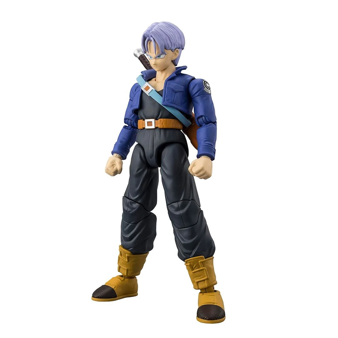 Figurka akcji Trunks z Dragon Ball w niebieskiej kurtce, czarnych spodniach i żółtych butach na białym tle.