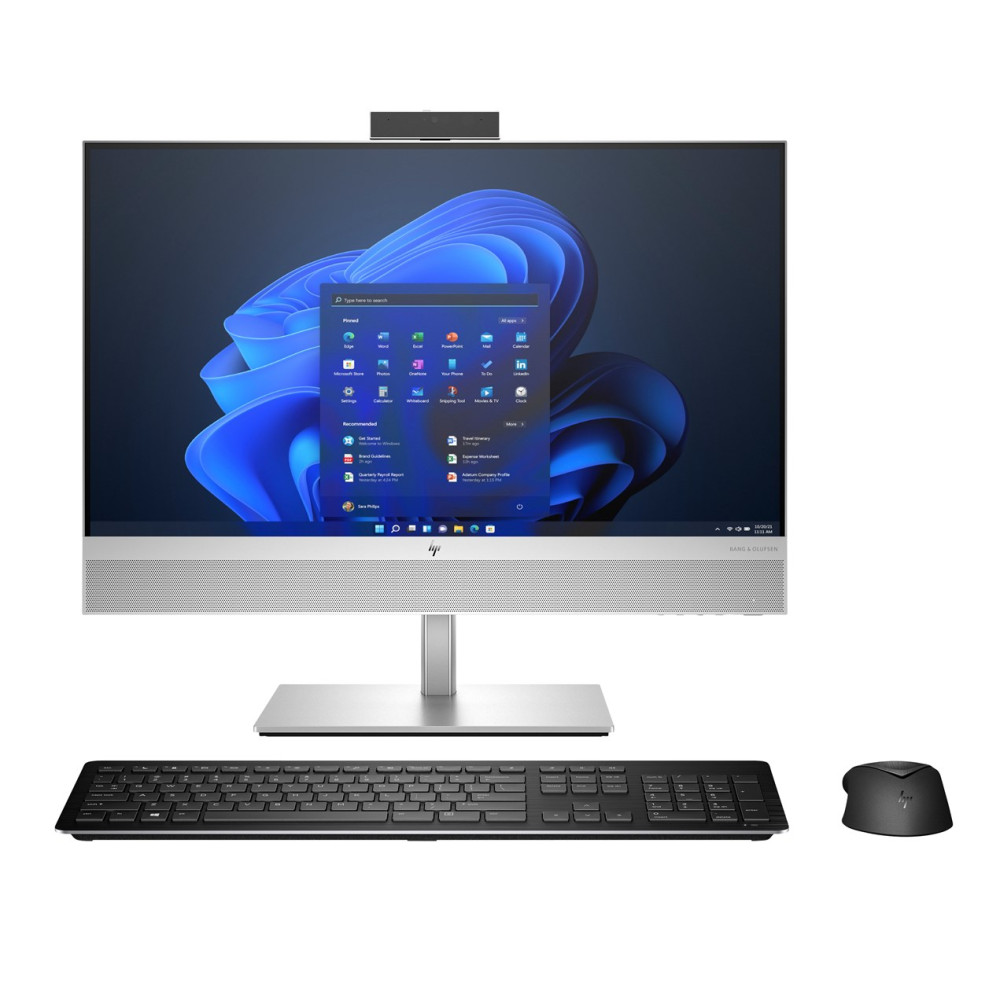 Komputer stacjonarny typu all-in-one z niebieską tapetą systemu Windows, czarną klawiaturą i myszą na białym tle.
