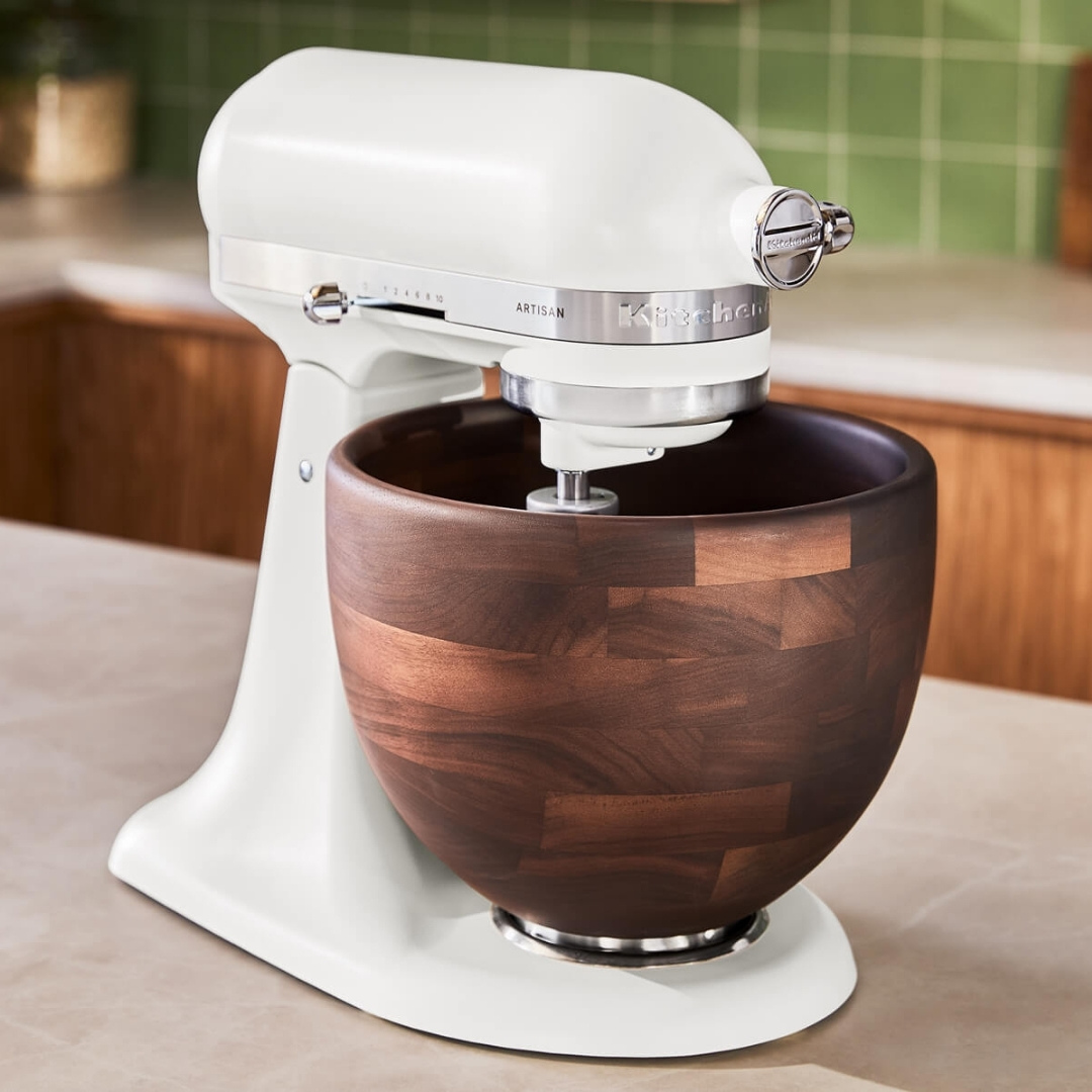 Mutfak tezgahı üzerinde koyu ahşap kaseli beyaz KitchenAid Artisan stand mikser.