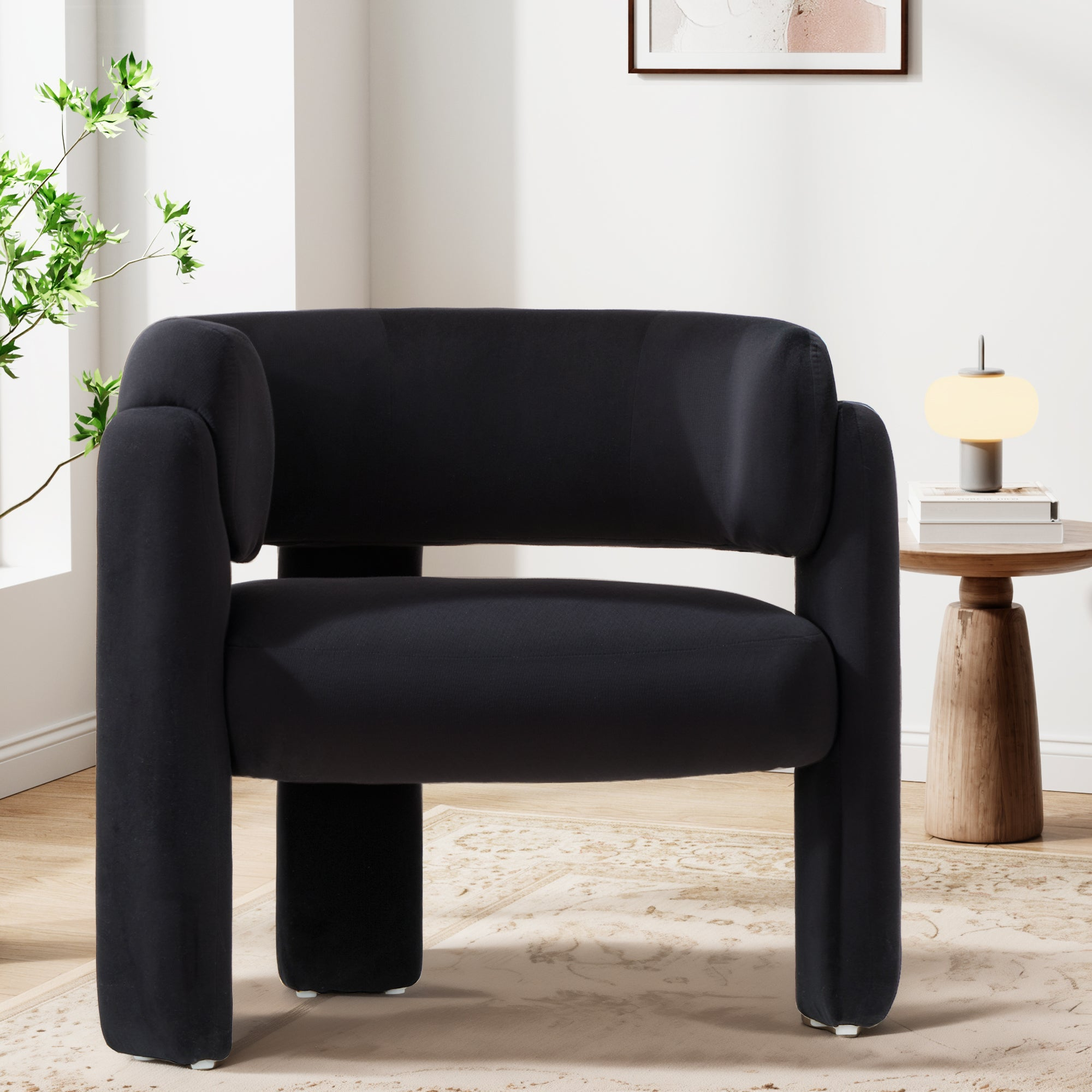 Una poltrona nera su un tappeto decorato in una stanza luminosa con un tavolino in legno e una lampada.