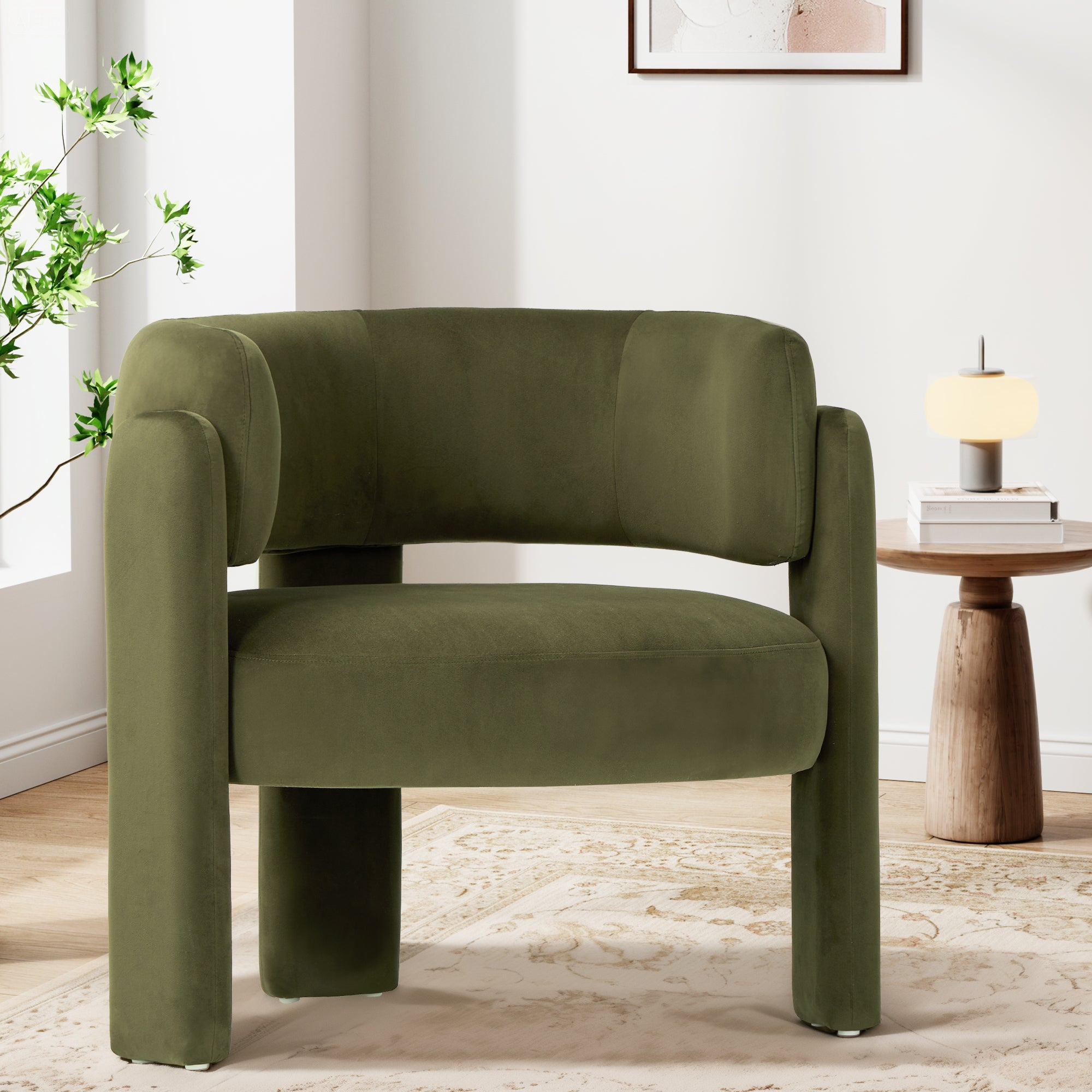 Una poltrona in velluto verde oliva su un tappeto in una stanza luminosa accanto a un tavolino.