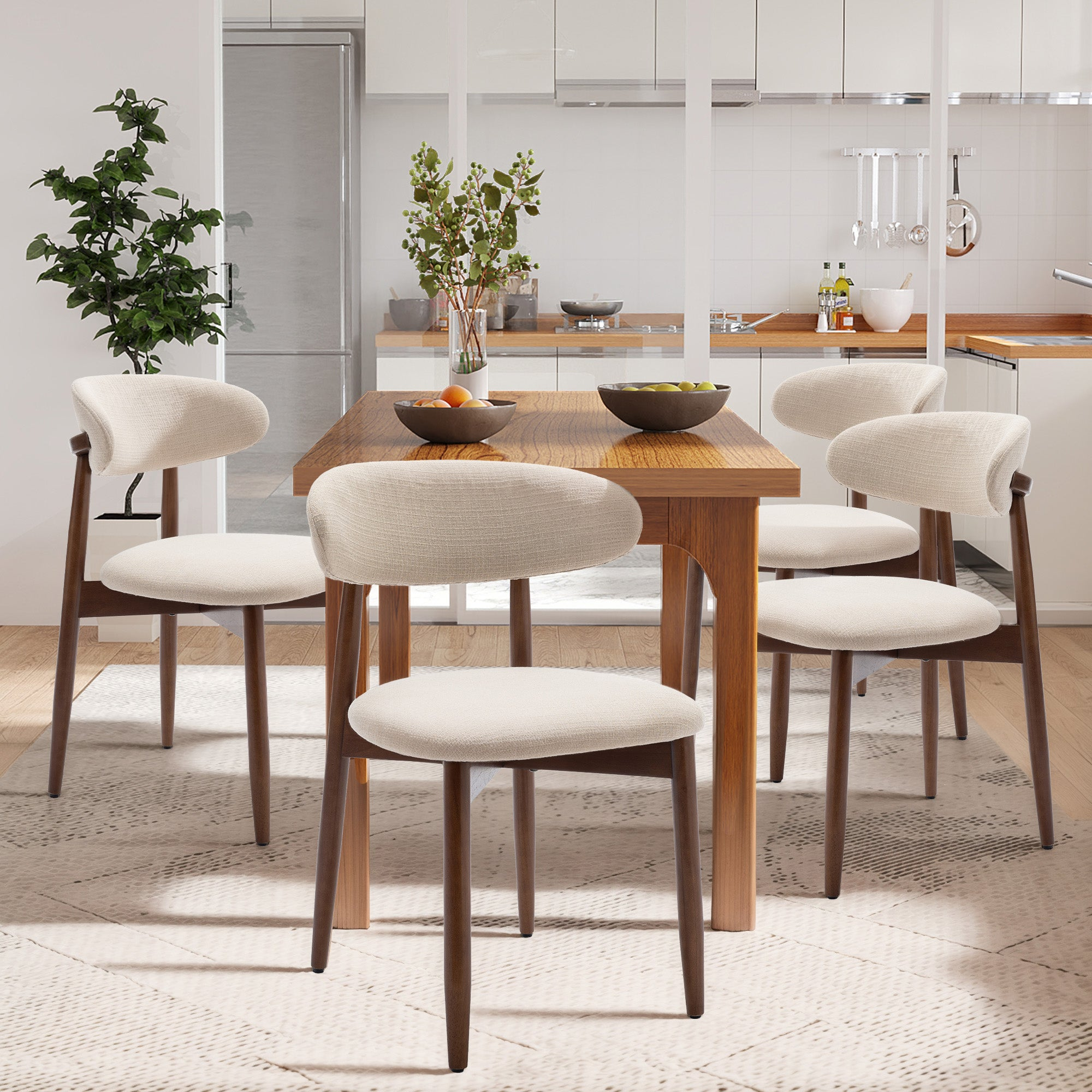 Esszimmer mit Holztisch und hellen Stühlen auf einem Teppich vor einer modernen Küche.