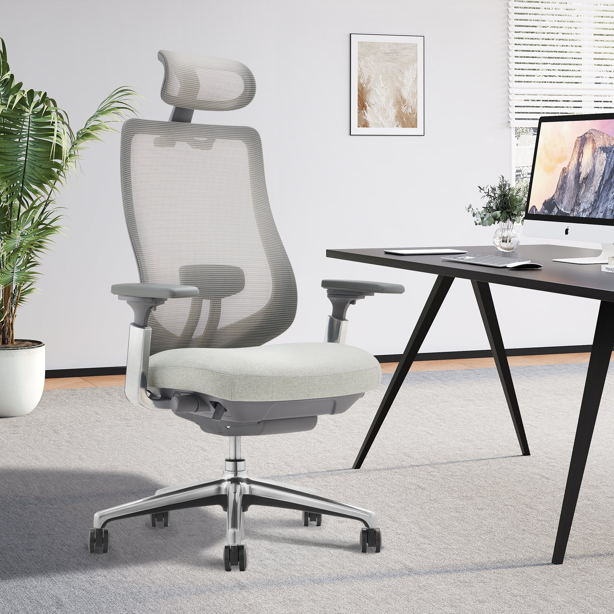 Ein grauer ergonomischer Burostuhl steht auf einem Teppich vor einem schwarzen Schreibtisch.