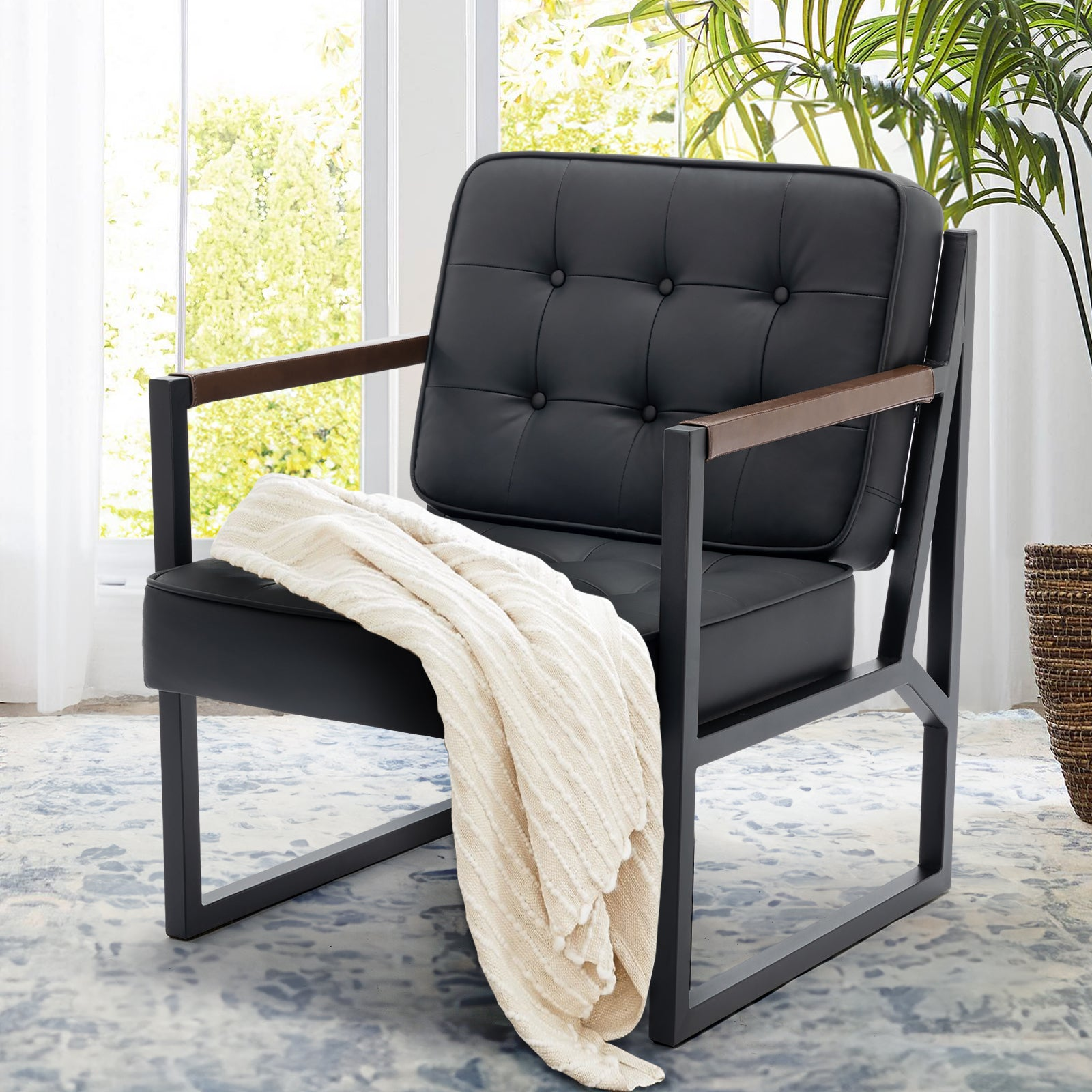 Una poltrona in pelle nera con struttura in metallo e coperta beige, su un tappeto decorato.