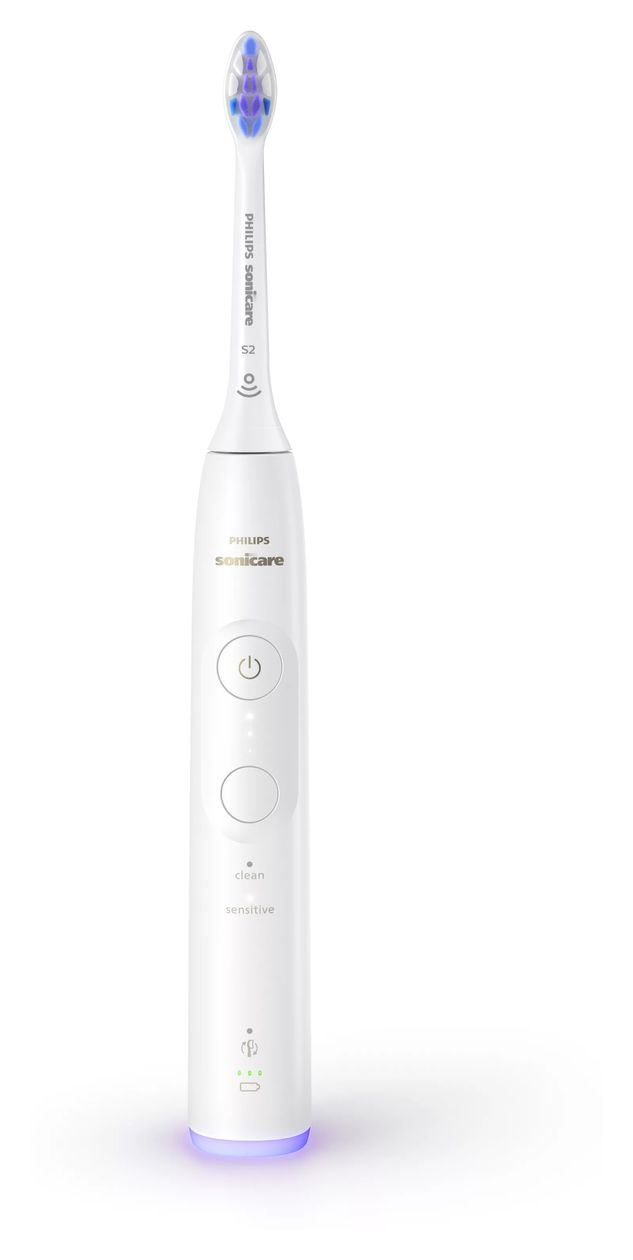 Uno spazzolino elettrico bianco Philips Sonicare con luce viola alla base su sfondo bianco.