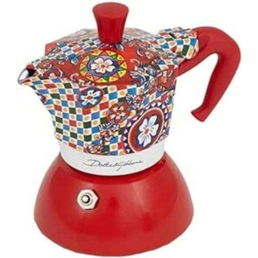 Una colorata caffettiera moka fantasia con base e manico rossi su sfondo bianco.