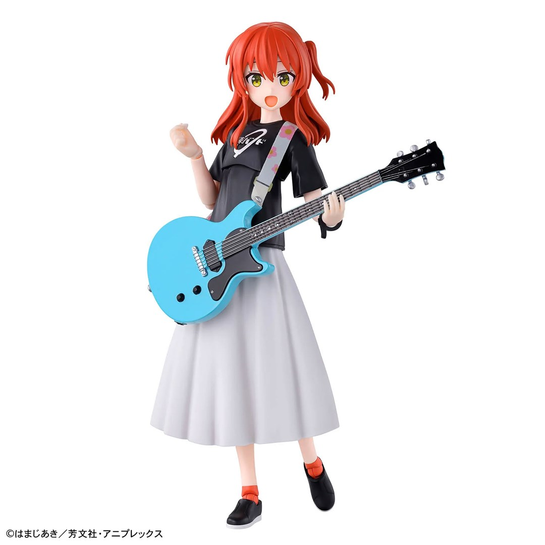 Figura anime z rudymi włosami i niebieską gitarą basową w czarnej koszulce i białej spódnicy na białym tle.