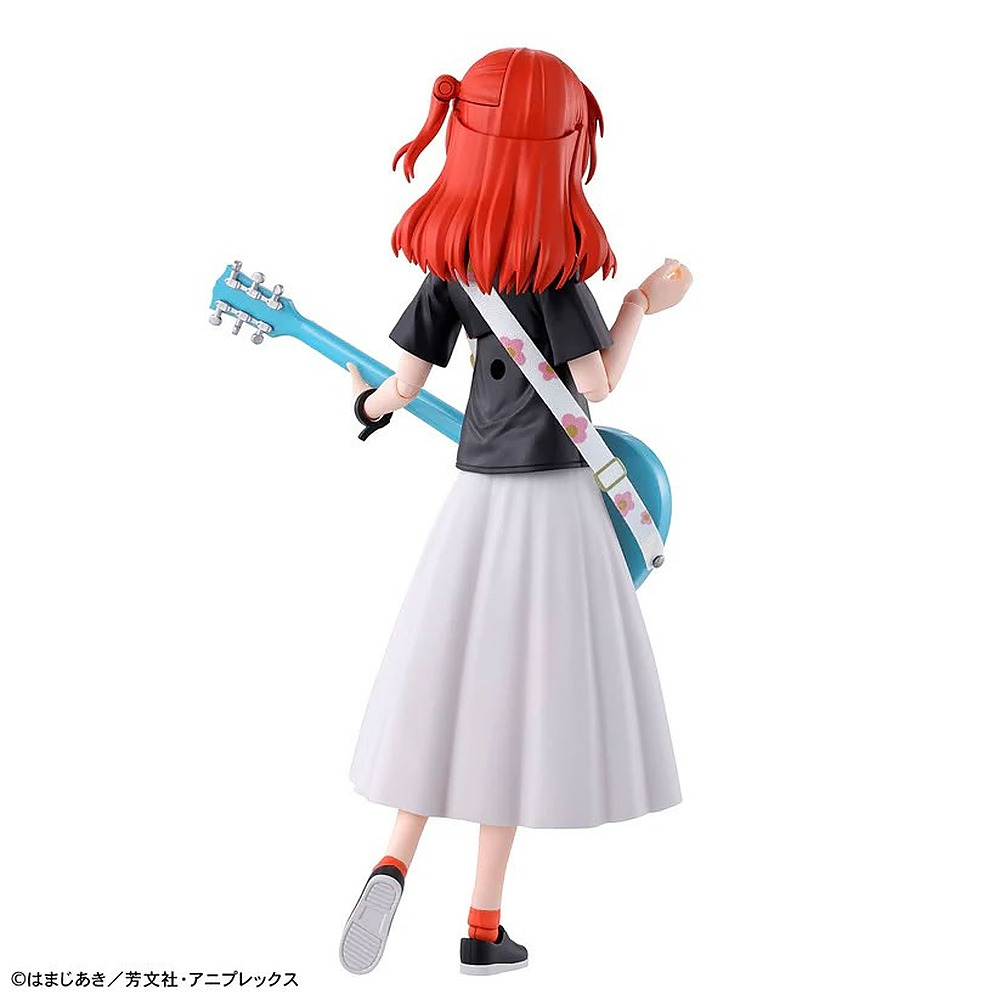 Figurka anime od tyłu z rudymi włosami, czarną bluzką, białą spódnicą i niebieską gitara elektryczną.