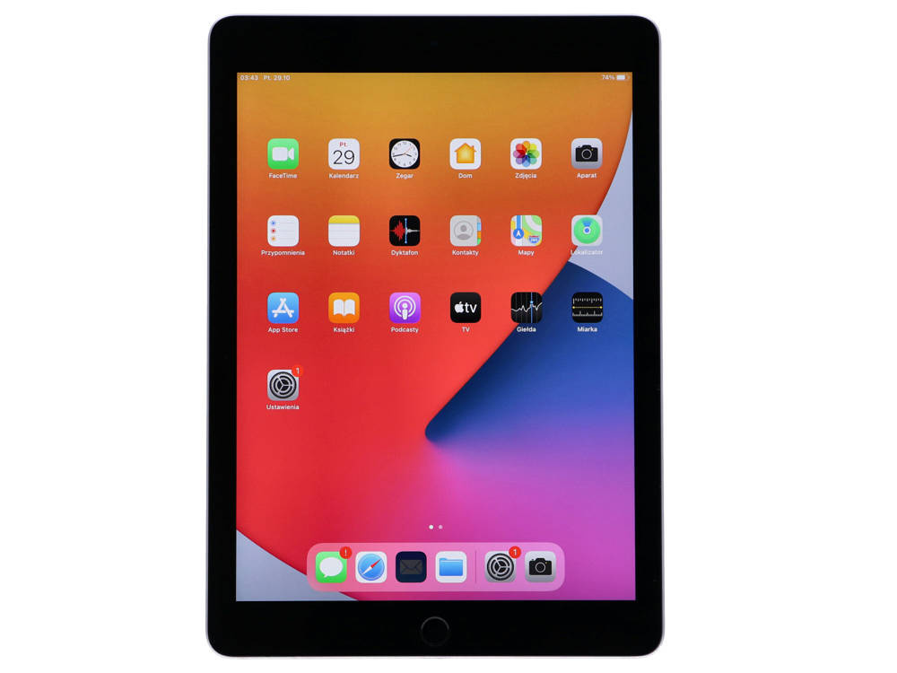 iPad z kolorową tapetą i różnymi ikonami aplikacji na ekranie na białym tle.