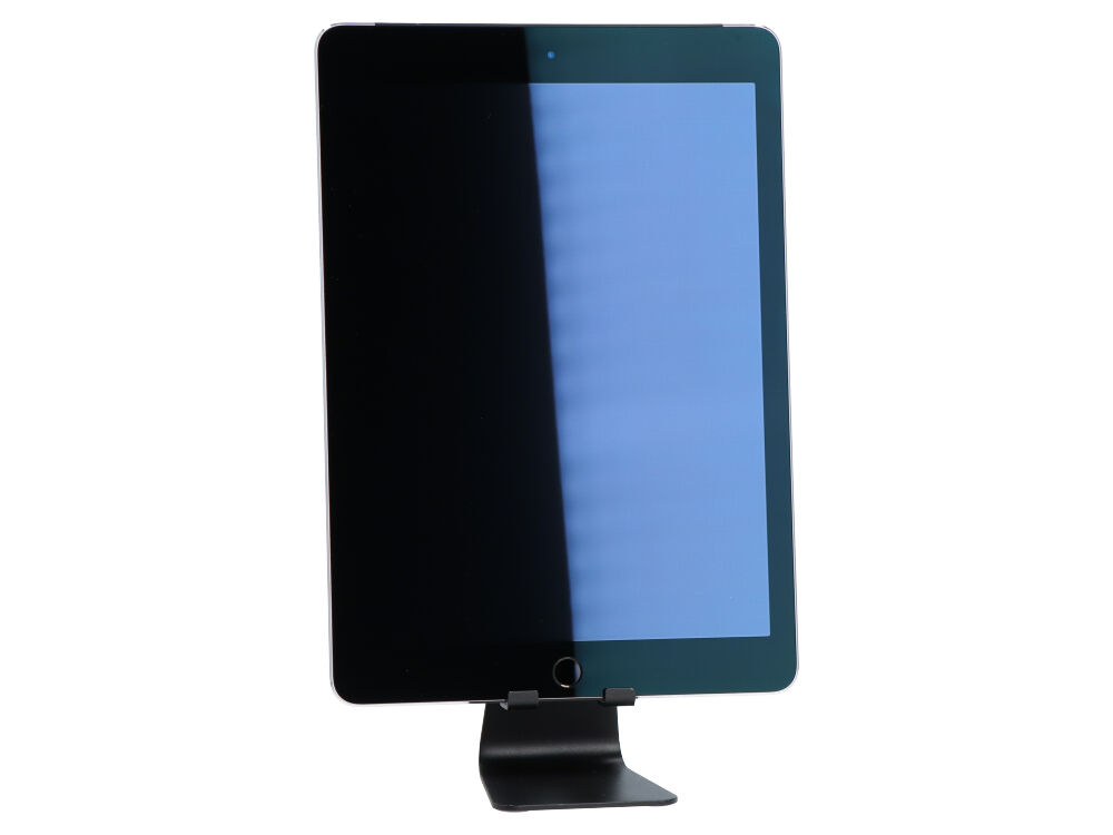 Tablet z ciemnym ekranem jest zamontowany na czarnym stojaku na białym tle.