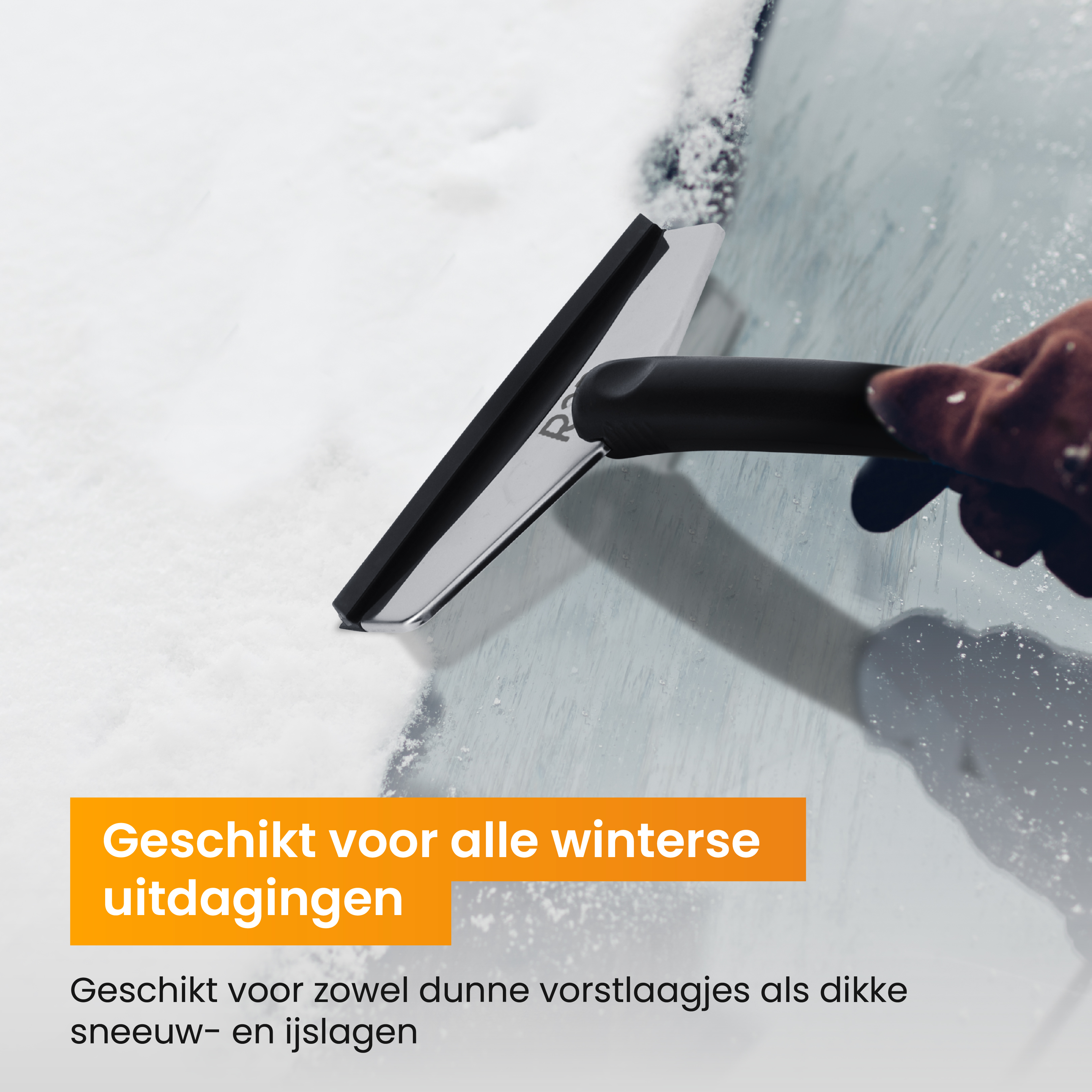 Eine behandschuhte Hand schabt Schnee und Eis mit einem Schaber von einer Autoscheibe.