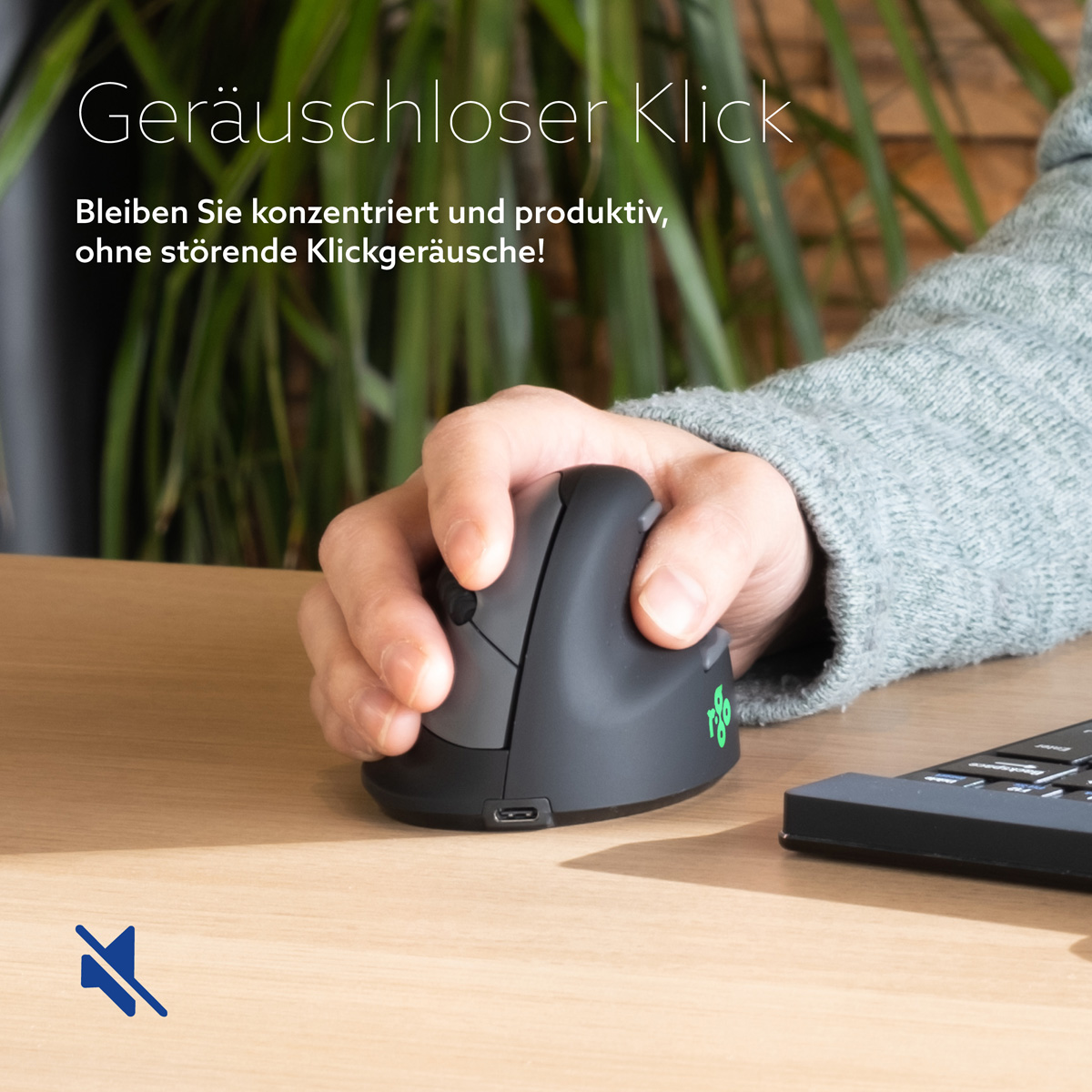 Mano che utilizza un mouse ergonomico verticale nero su una scrivania di legno con piante sullo sfondo.