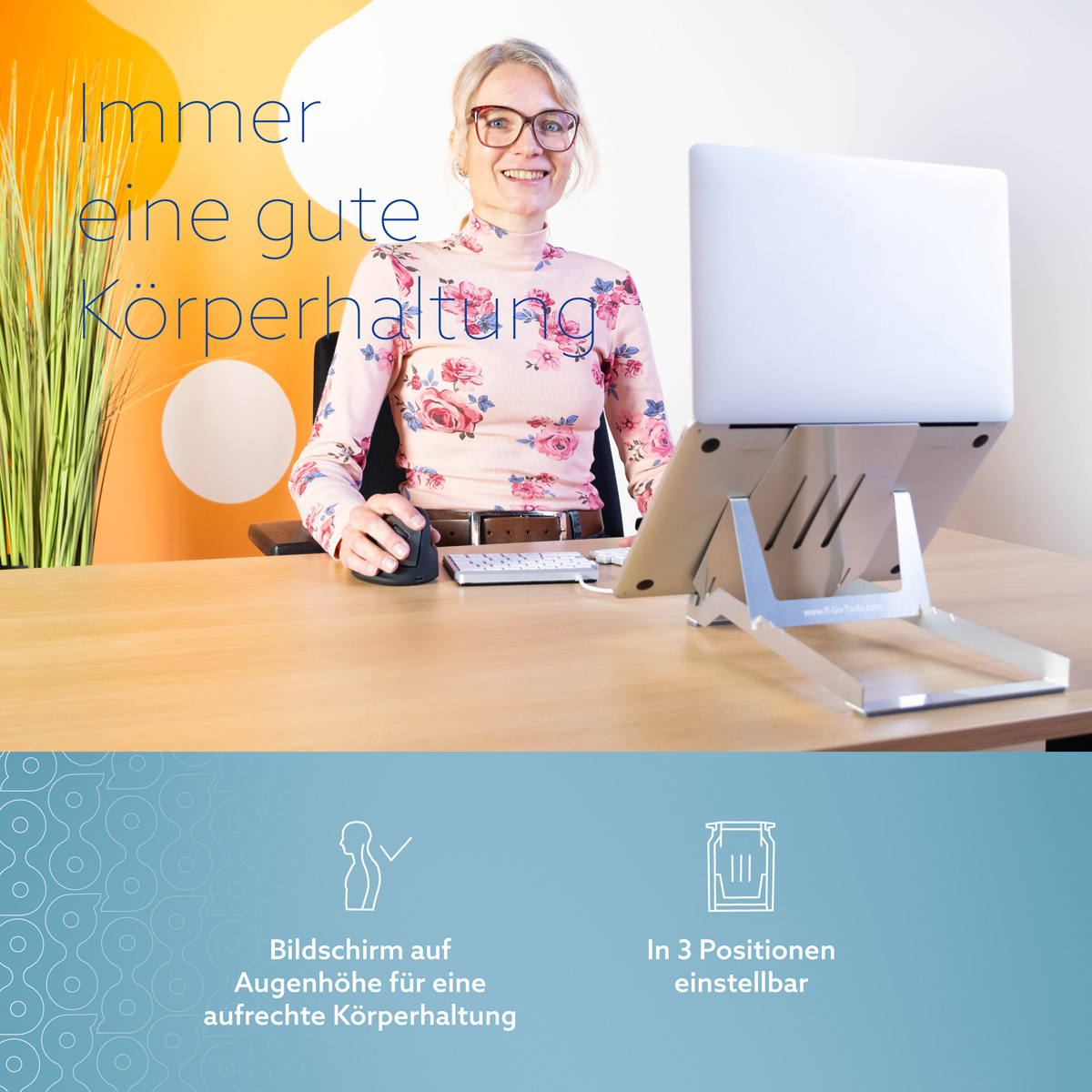 Eine lächelnde Frau nutzt einen Laptop auf einem Ständer an einem Holztisch.
