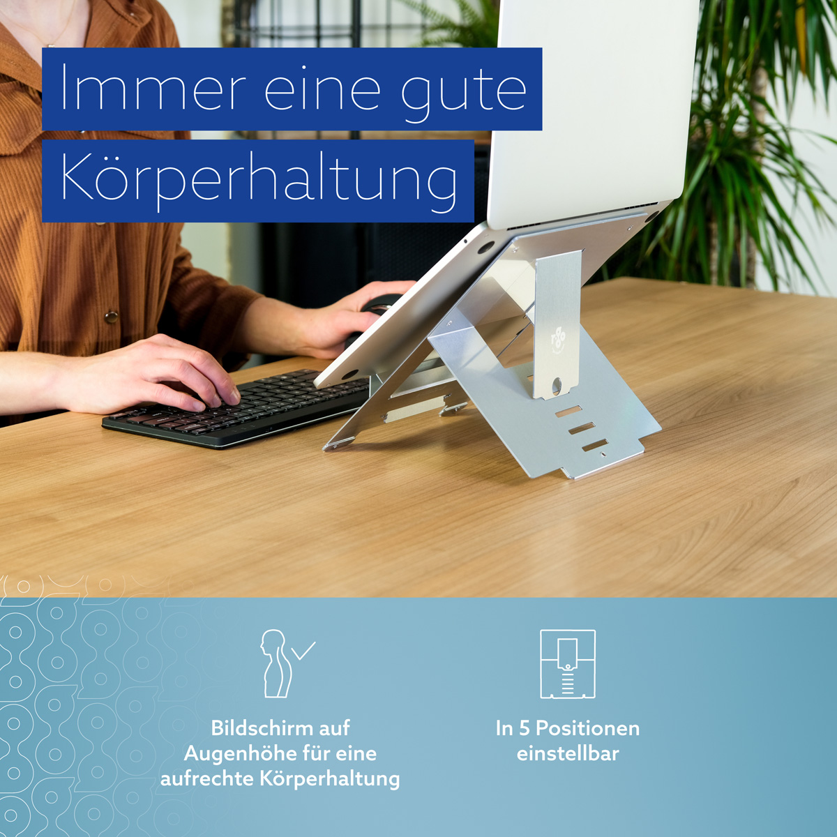 Ein Laptop auf einem verstellbaren silbernen Ständer auf einem Holzschreibtisch.