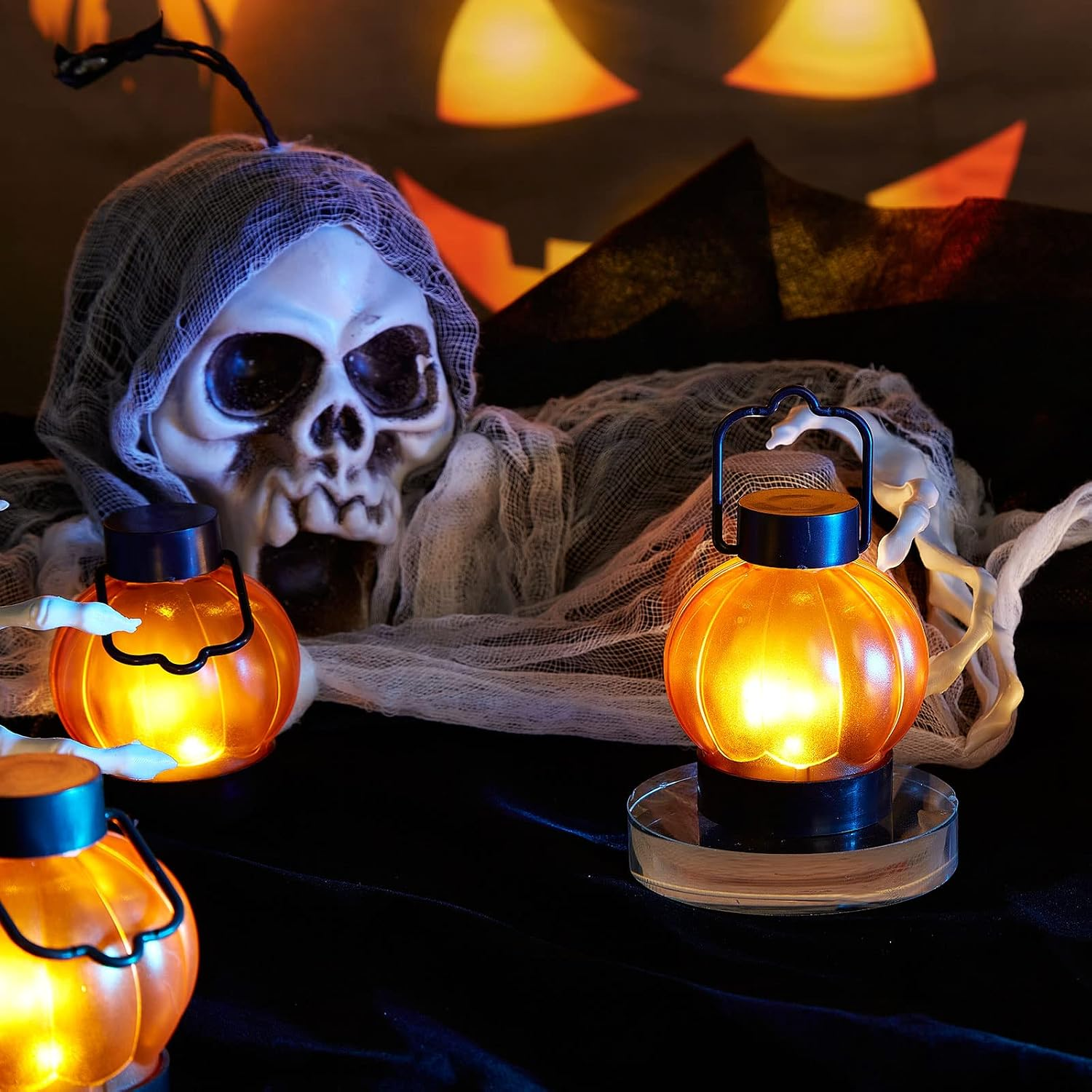 Ein Totenkopf mit weißem Stoff und gruseligen Kürbislaternen vor einem leuchtenden Hintergrund.
