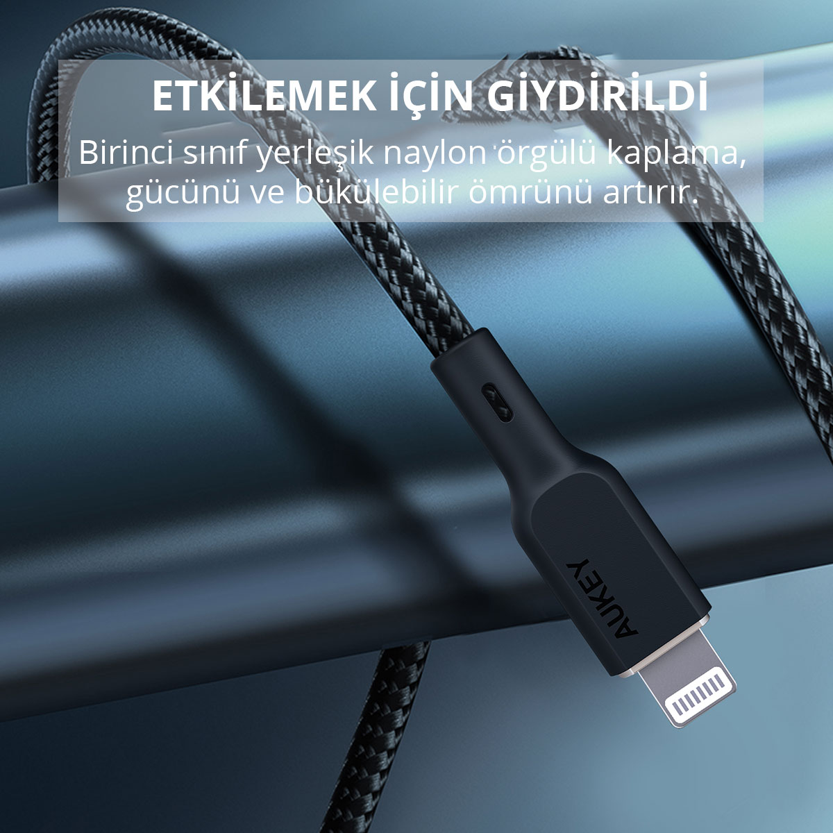 AUKEY Lightning konnektörlü siyah örgülü USB kablosu, mavi metal silindire sarılmış.