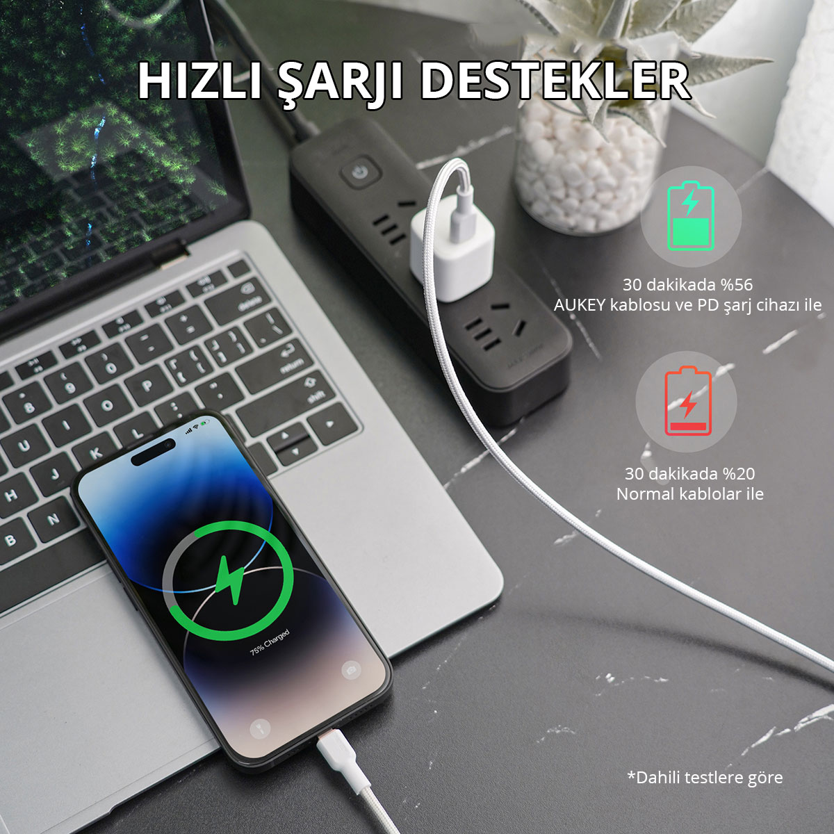 Koyu renkli masada akıllı telefon ve dizüstü bilgisayar, priz ve şarj kablosu.