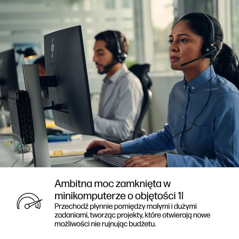 Pracownica call center w słuchawkach pracuje przy komputerze w biurze.