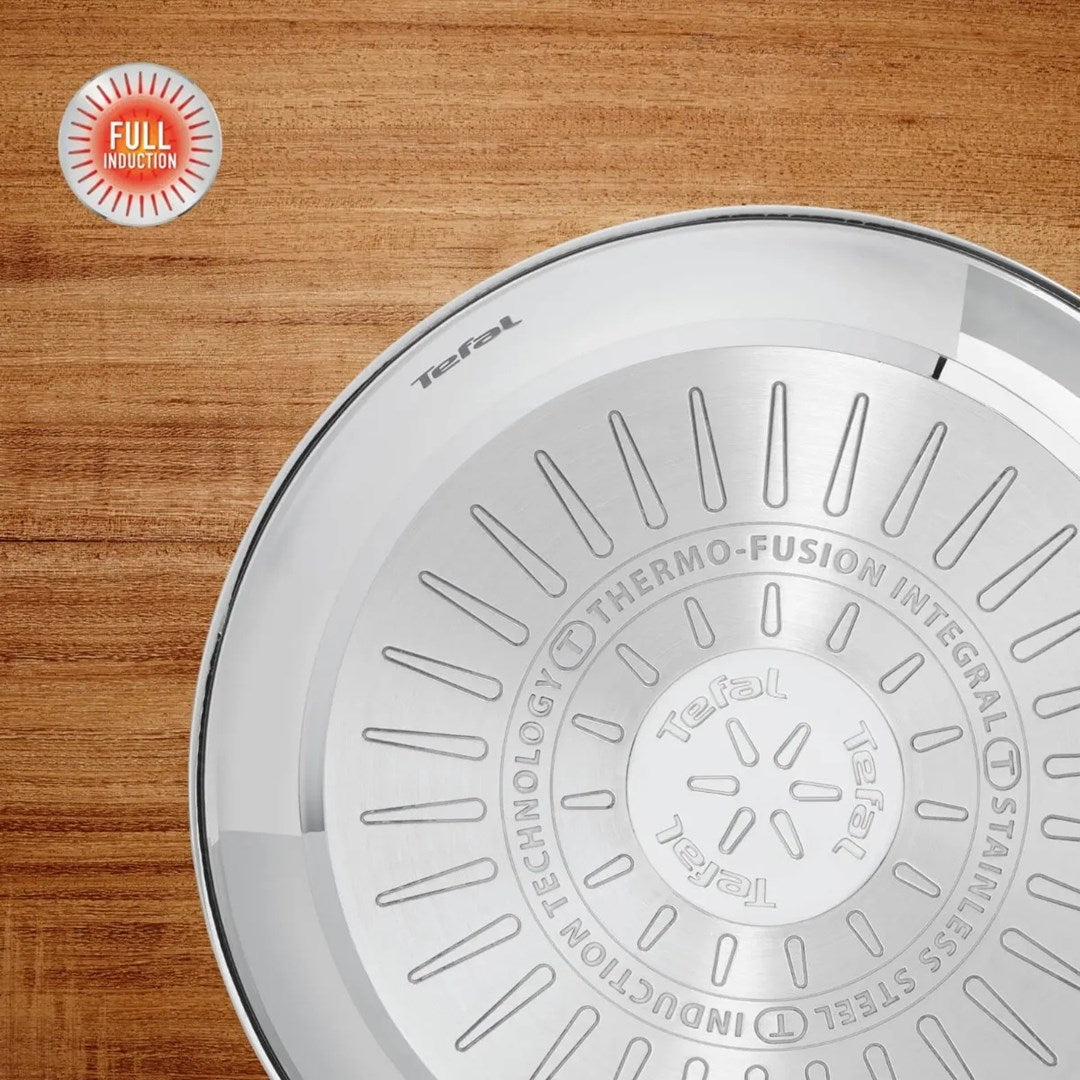 Spód patelni ze stali nierdzewnej Tefal z technologią Thermo-Fusion na drewnie.