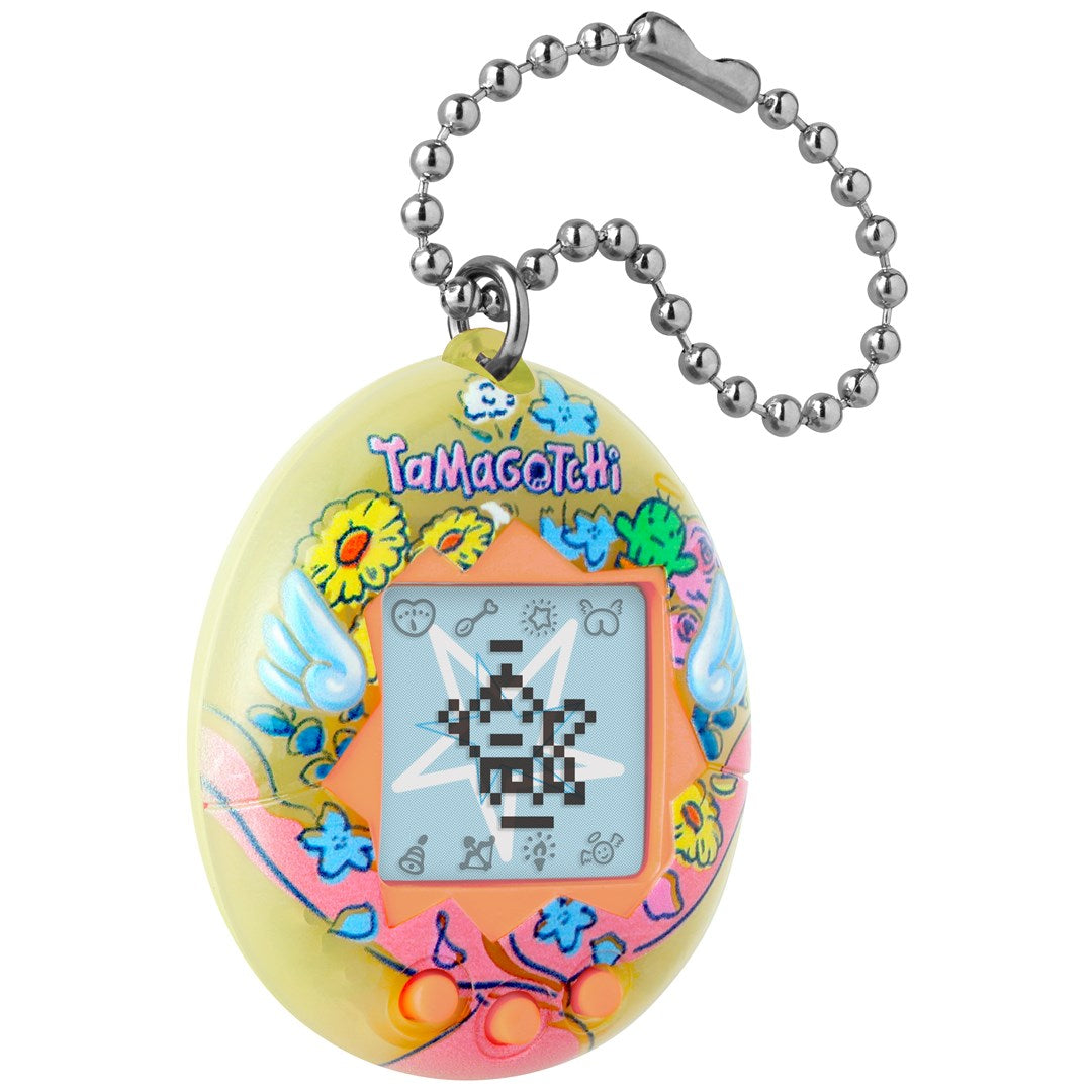 Żółte Tamagotchi z motywami kwiatowymi, ekranem LCD i srebrnym łańcuszkiem kulkowym na białym tle.