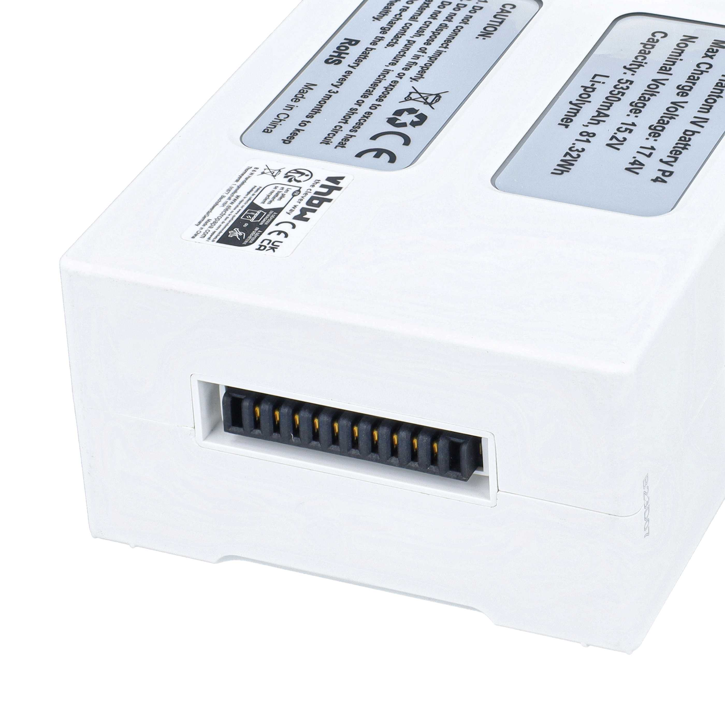 Nahaufnahme eines weißen Batterieanschlusses mit vergoldeten Pins und Warnhinweisen.
