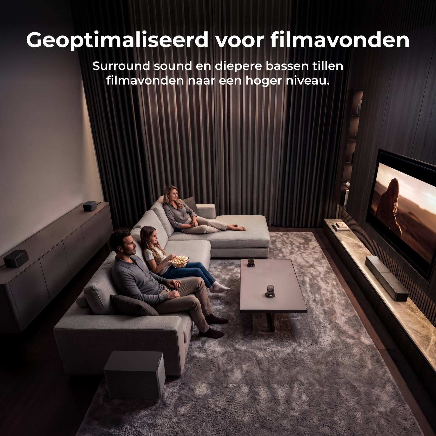 Een gezin zit op een bank in een gezellige woonkamer en kijkt naar een film op een grote tv.