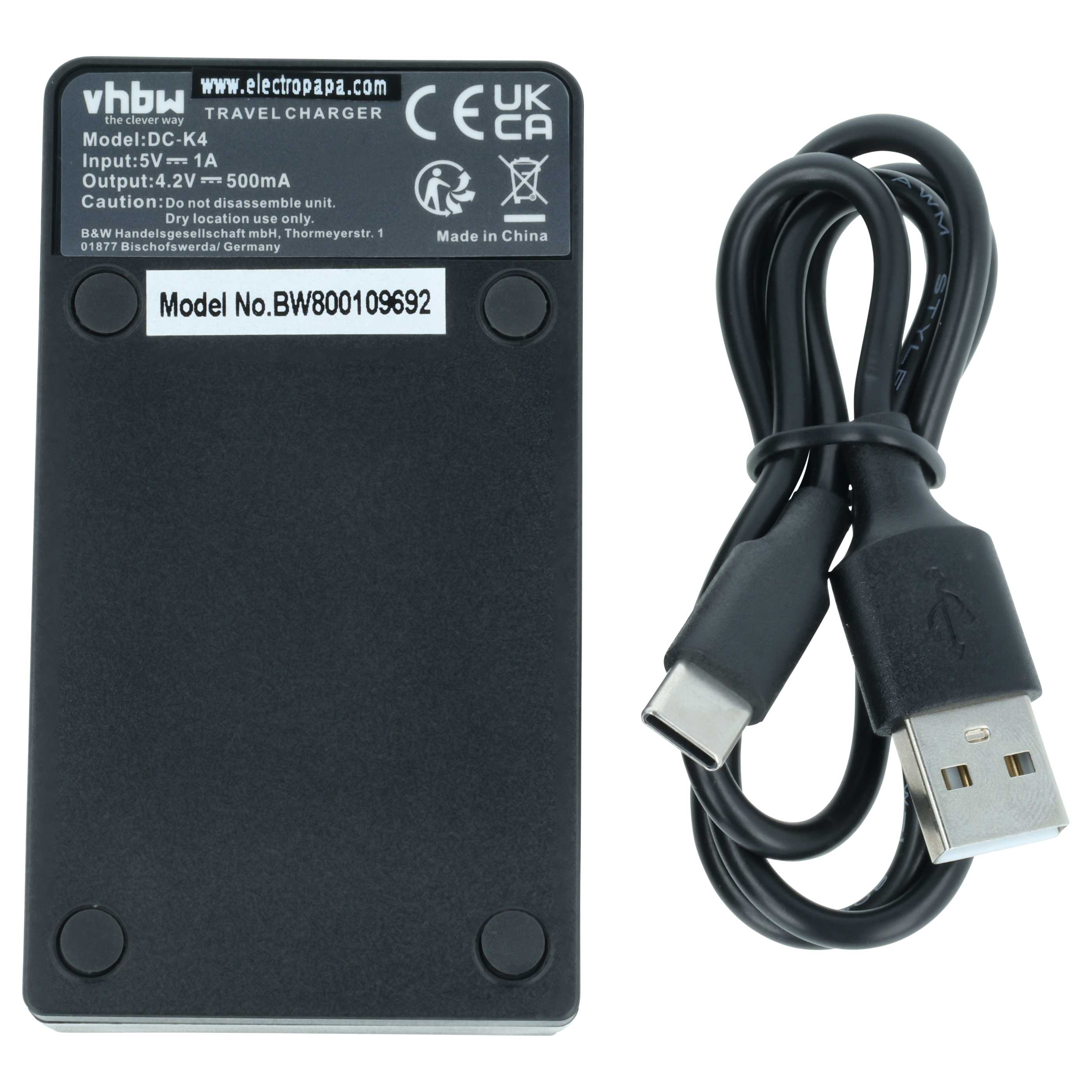 Ein schwarzes Reise-Ladegerät mit technischem Text und einem zusammengerollten USB-Kabel daneben.