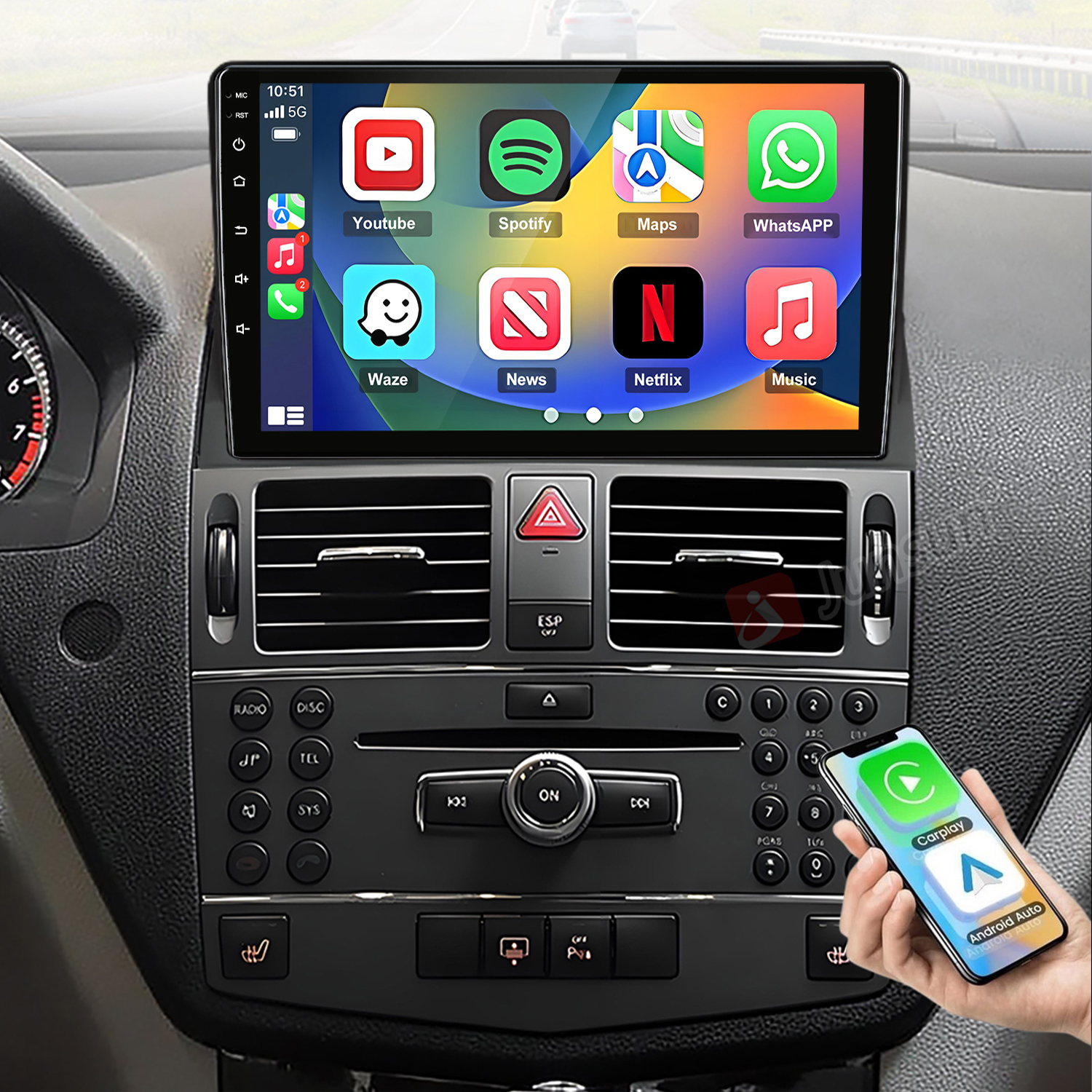 Das Armaturenbrett eines Autos zeigt einen großen Touchscreen mit App-Icons, Lüftungsschlitzen, Bedienelementen und ein Handy.
