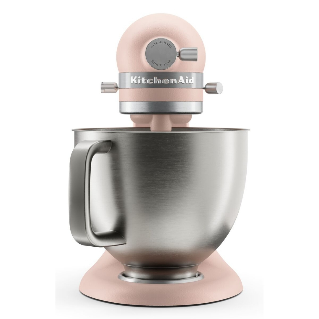 Beyaz arka planda paslanmaz çelik karıştırma kaseli pembe bir KitchenAid stant mikser.