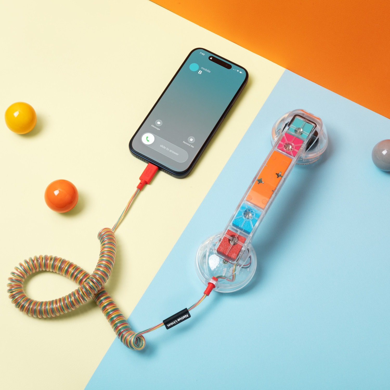 Smartfon połączony z kolorową słuchawką telefoniczną na kolorowym tle.