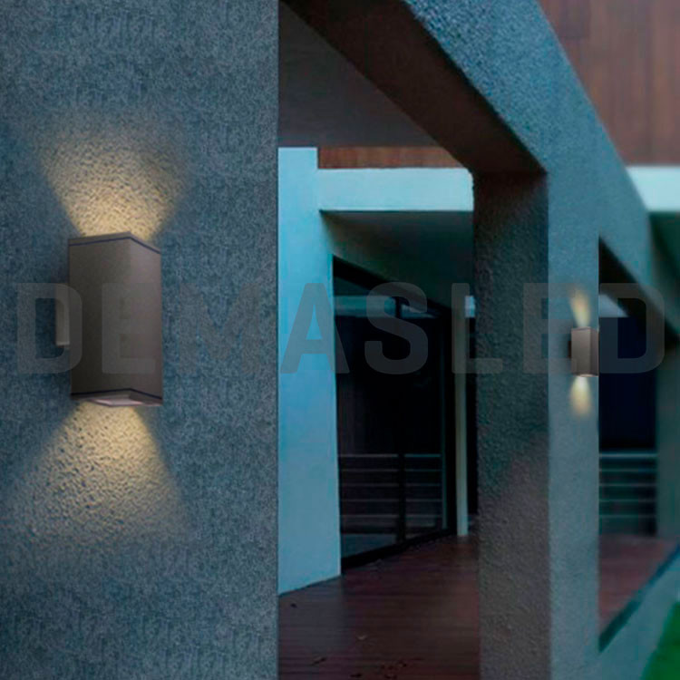 Lámparas de pared grises modernas proyectan luz suave en la fachada exterior de un edificio.