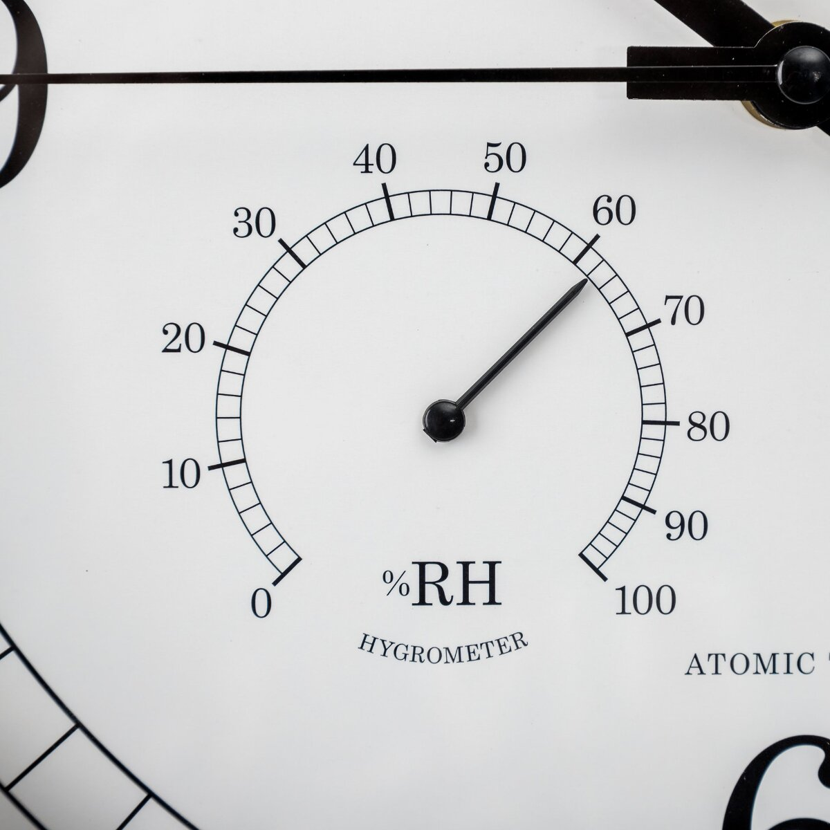 Ein weißes Hygrometer mit schwarzer Skala und Zeiger zeigt etwa 63 Prozent Luftfeuchtigkeit.